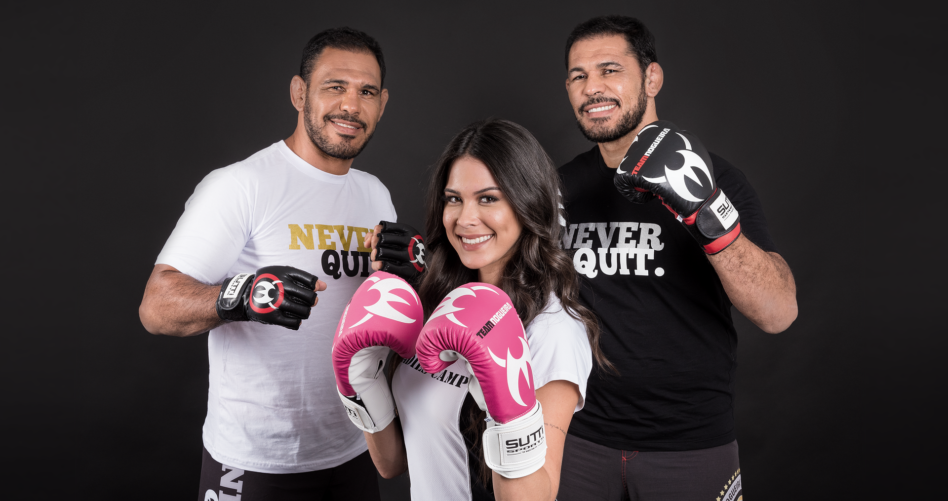 Dois homens e uma mulher usando luvas de boxe estão posando para uma foto.