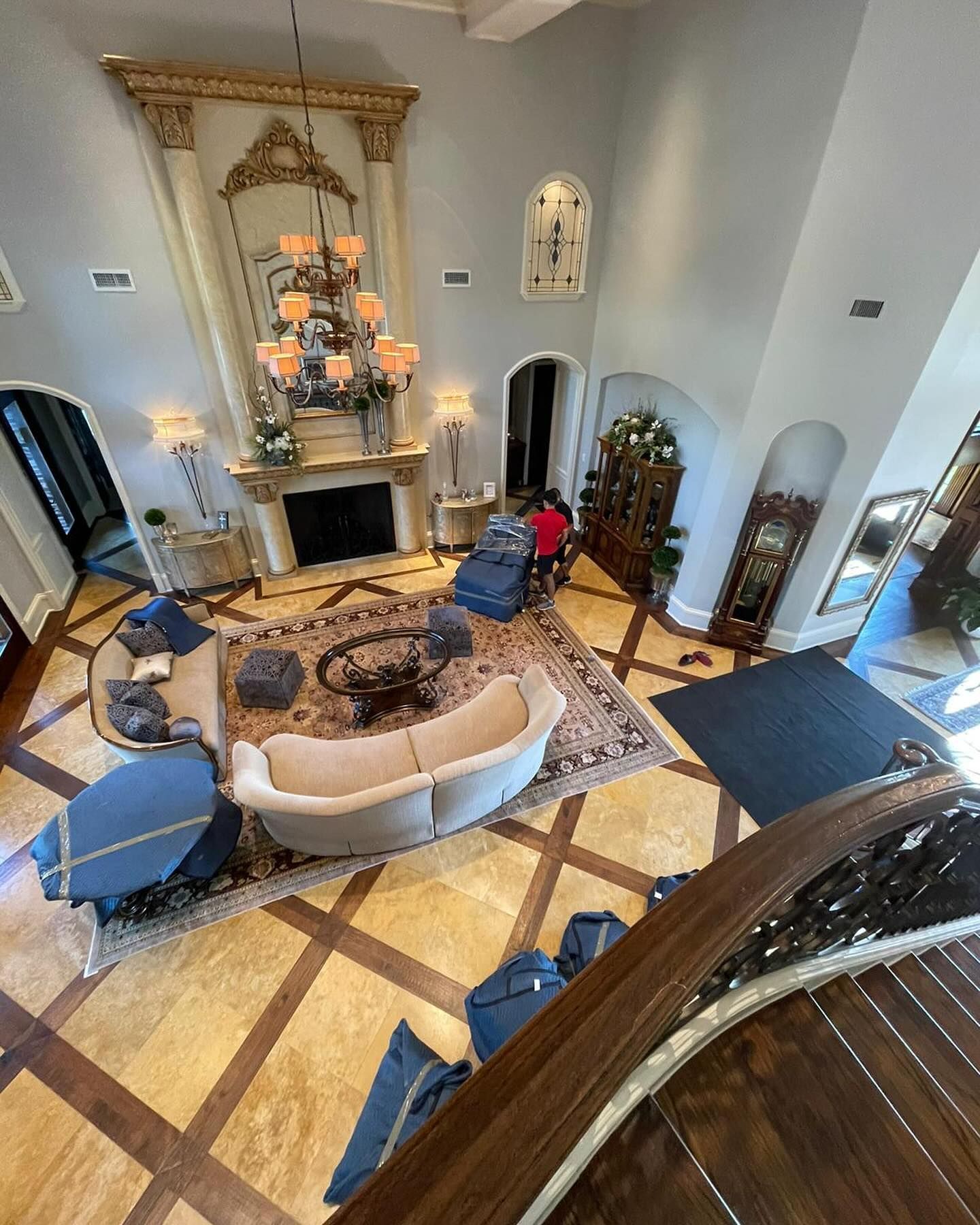 High-angle view of a luxurious living room with a fireplace, ornate mirror, and elegant furniture.