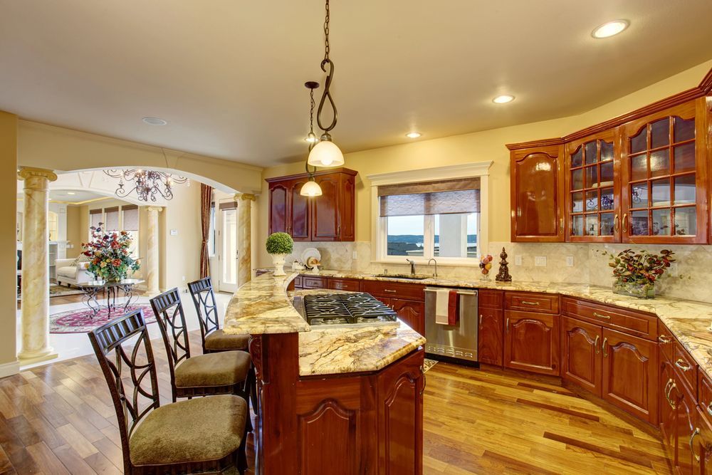 Spacious kitchen with wood cabinets, granite countertops, and a central island with seating.
