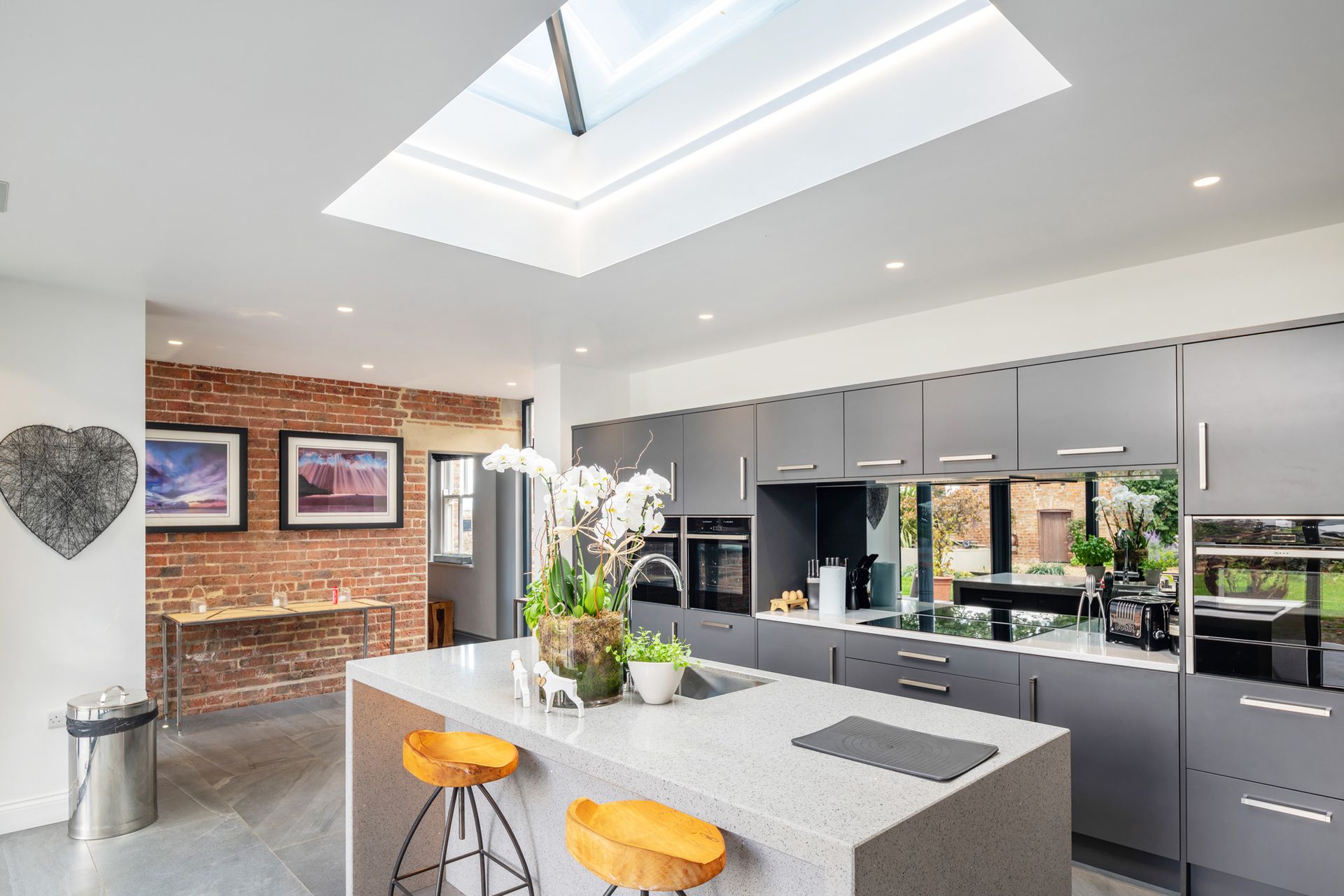 A kitchen with a large island and a skylight above it.