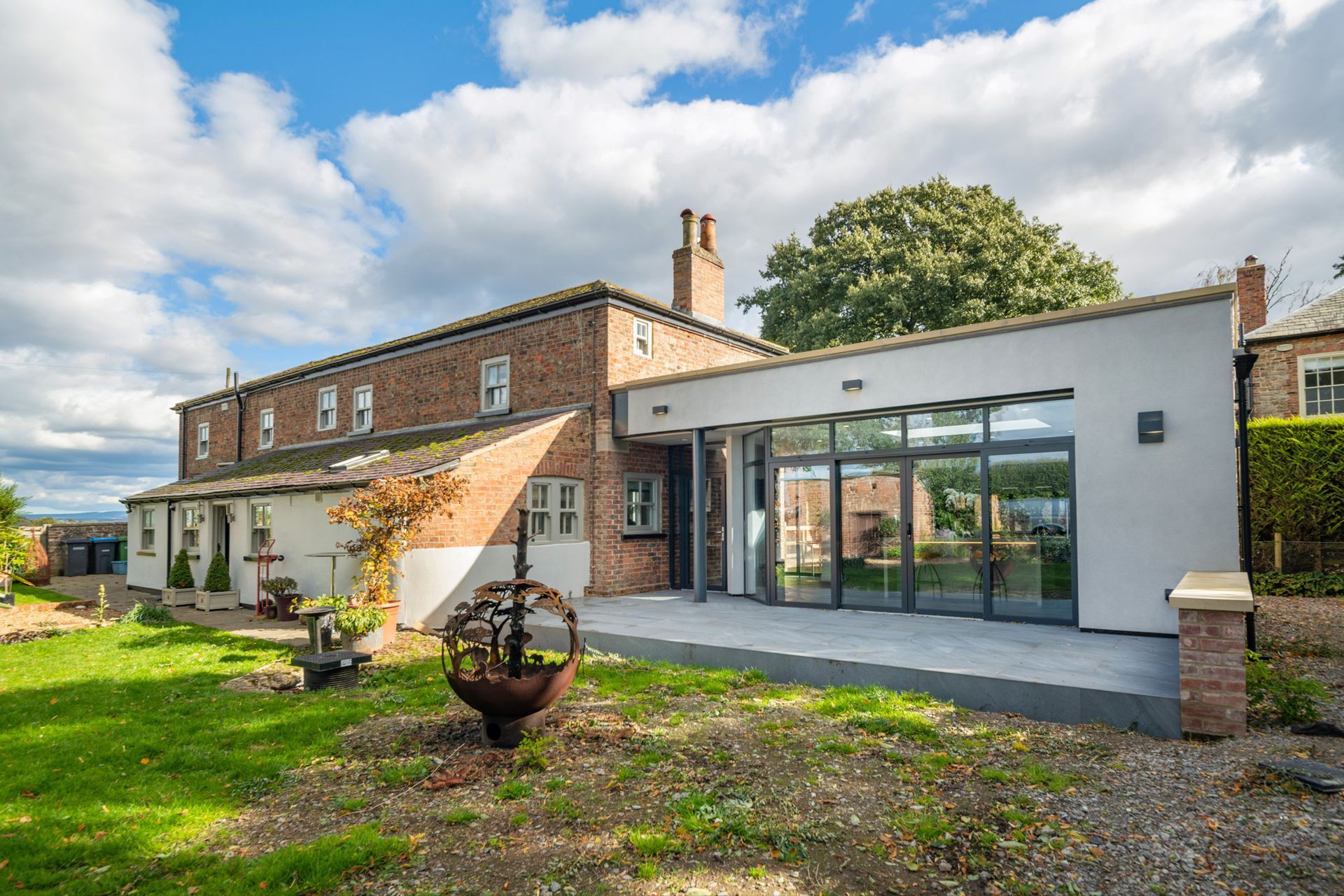 A large brick house with a large patio in front of it.
