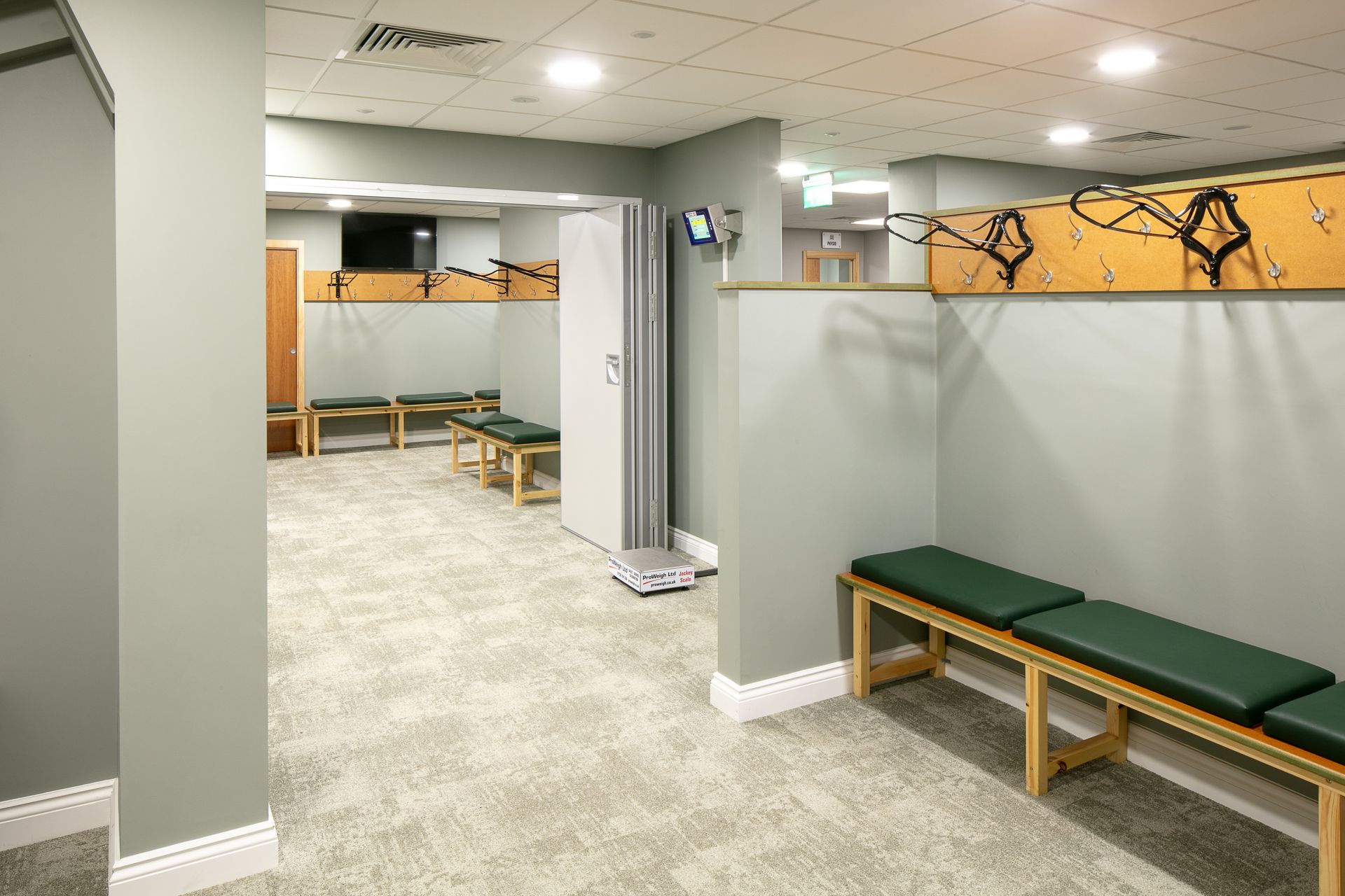 A locker room with benches and a scale on the floor.