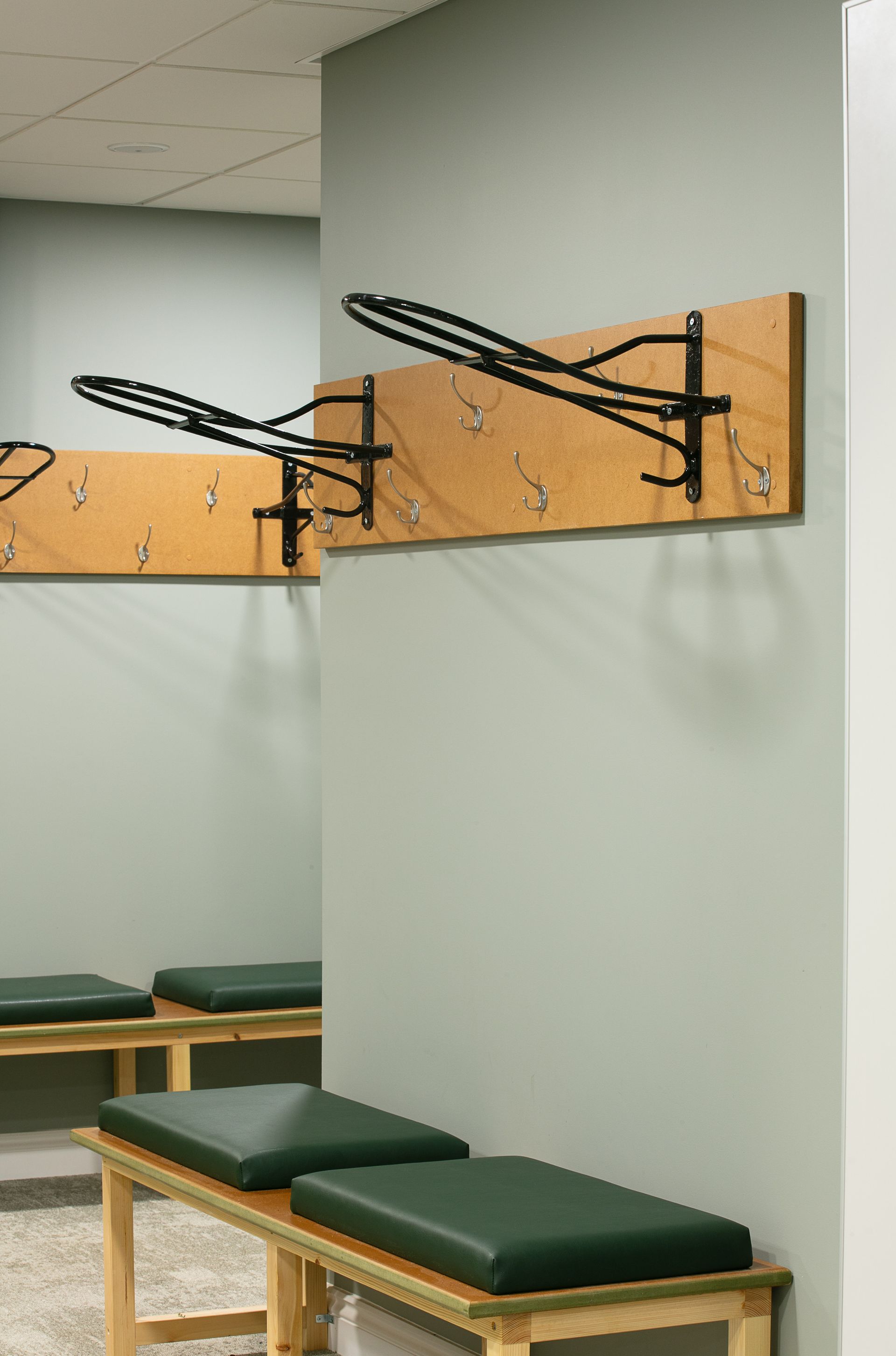 A locker room with benches and hooks on the wall