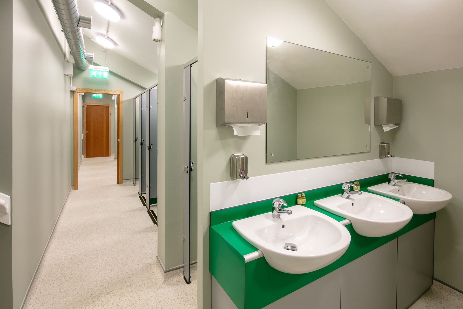 A bathroom with three sinks and a mirror