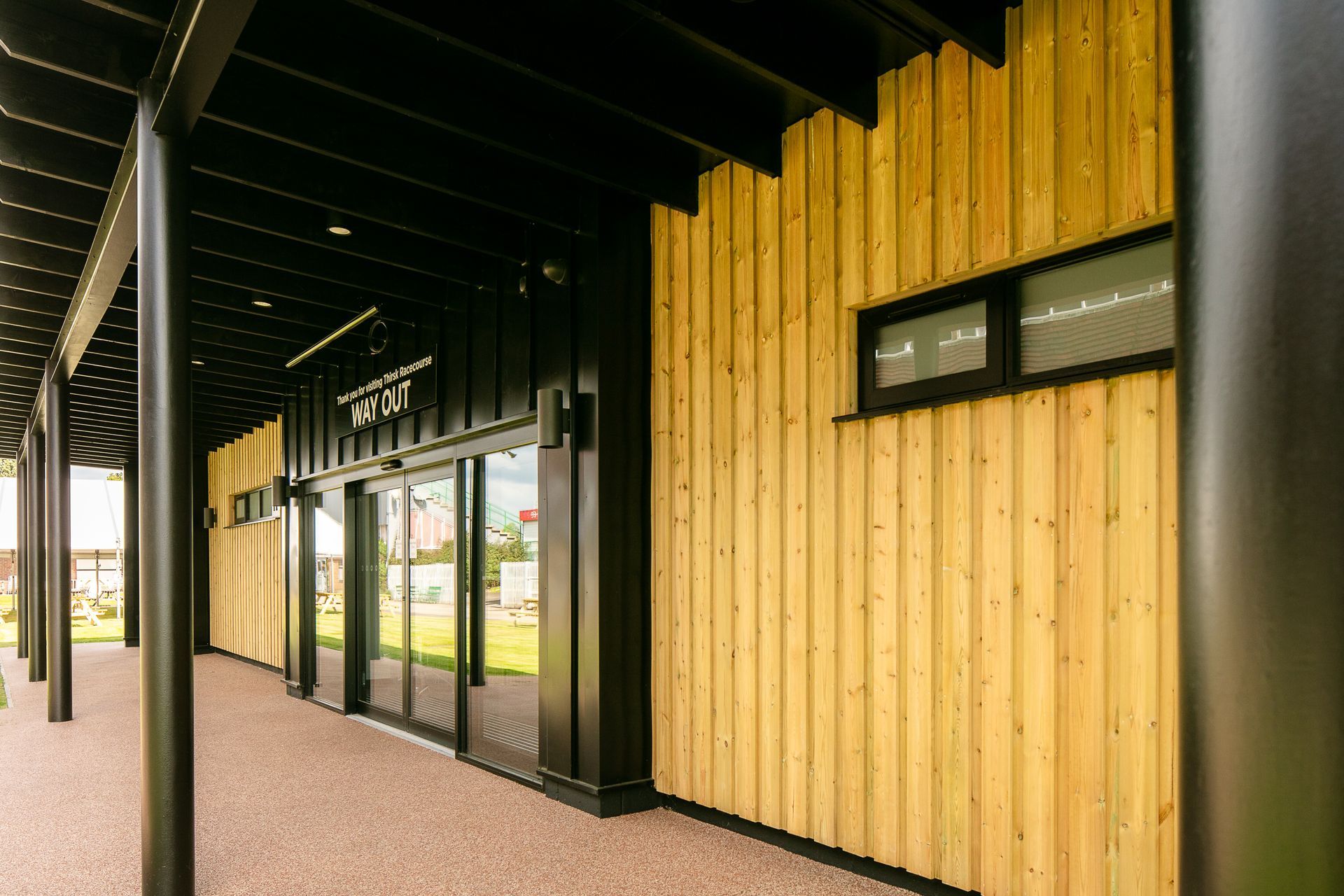A large building with a wooden facade and sliding glass doors.