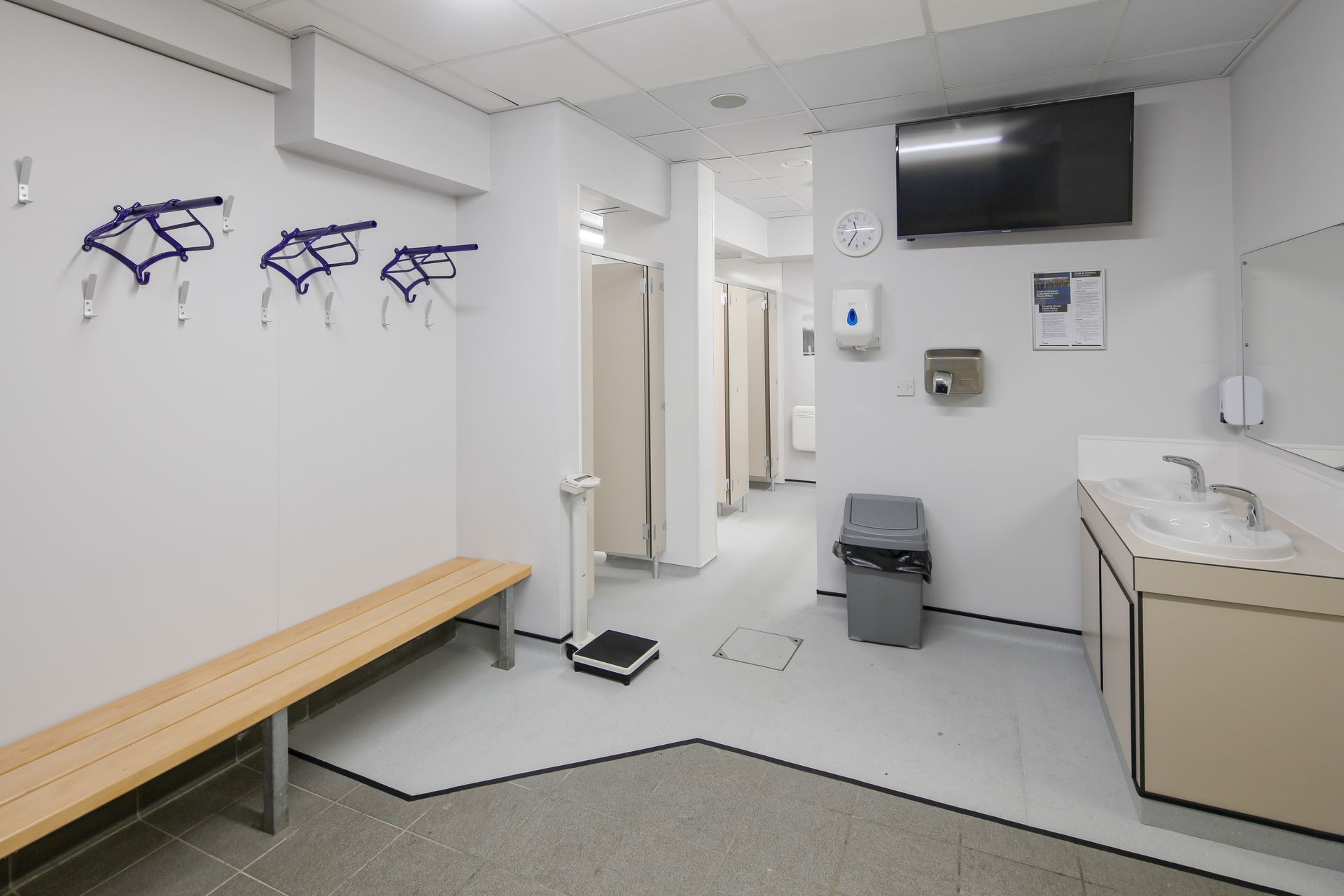 A locker room with a bench and a sink