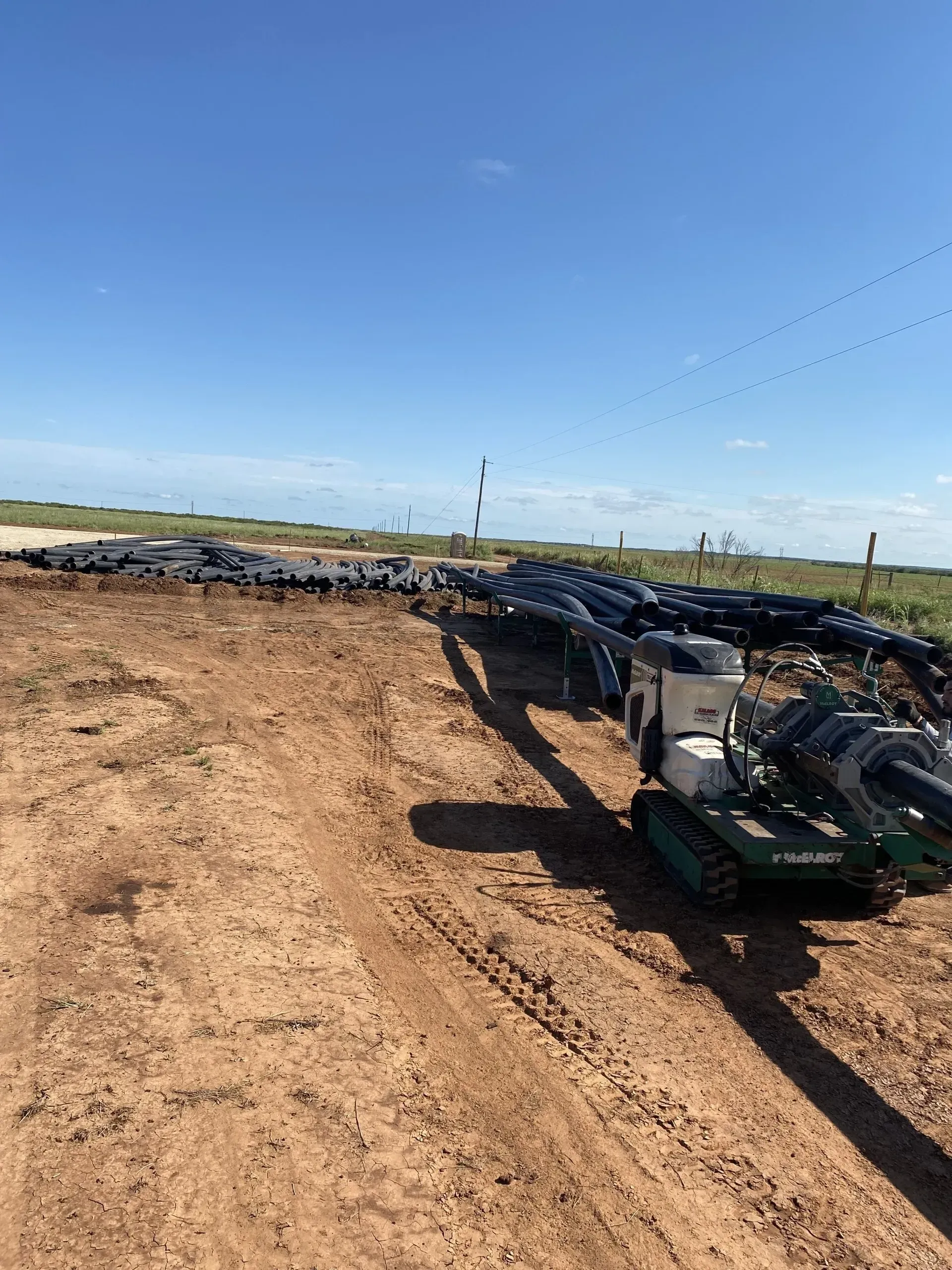 A tractor is sitting in the middle of a dirt field.