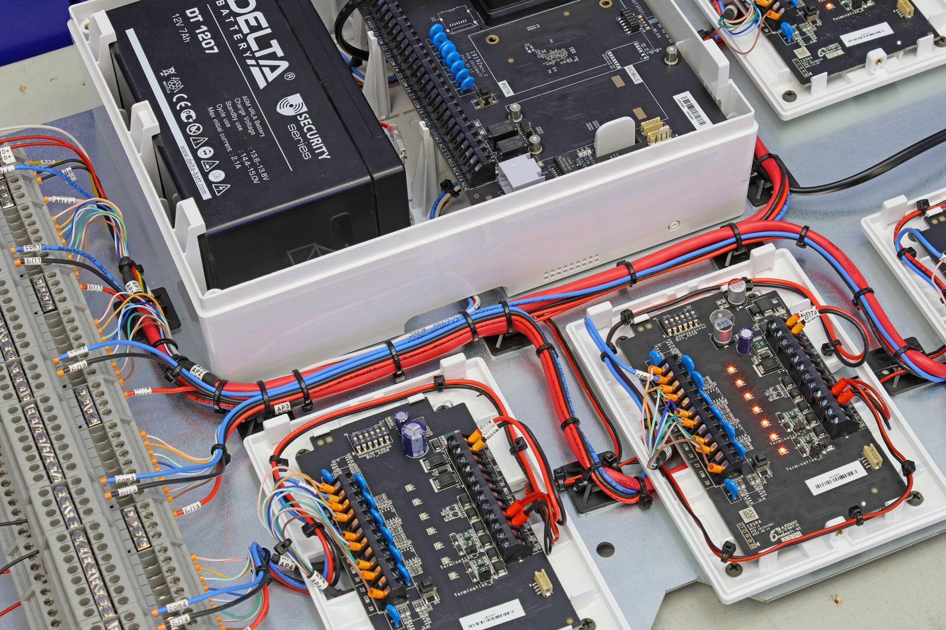 Electrical control panel with circuit boards, wiring, and a battery in an industrial setup