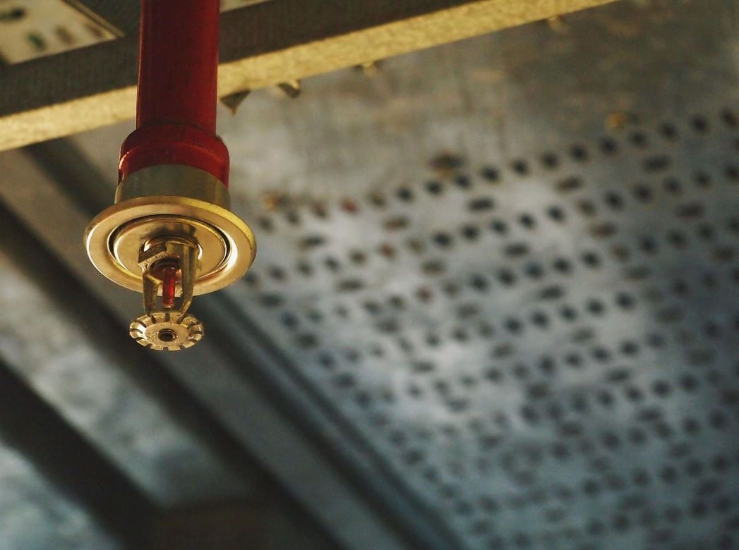 A fire sprinkler is hanging from the ceiling of a building.
