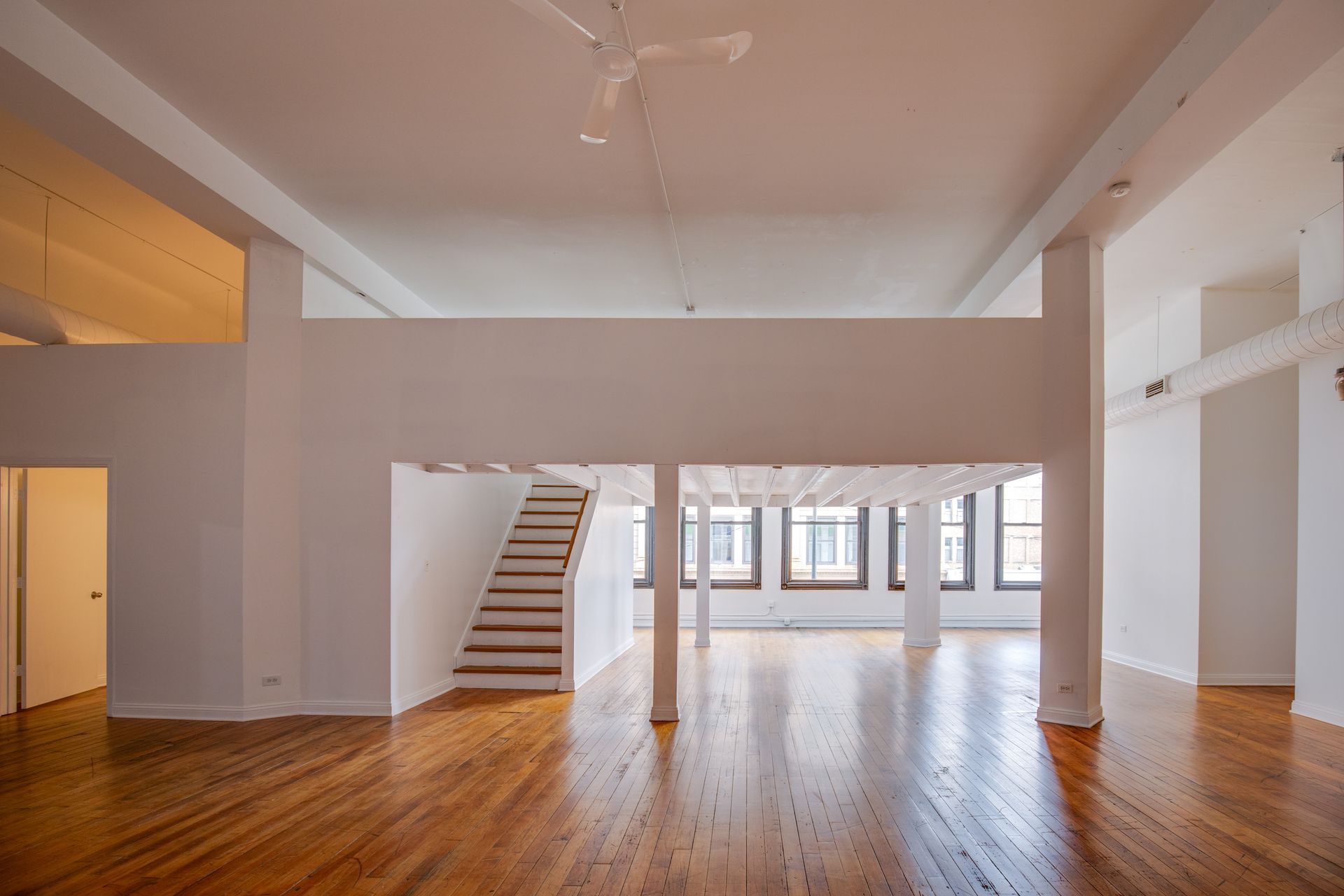 A large empty room with hardwood floors and white walls