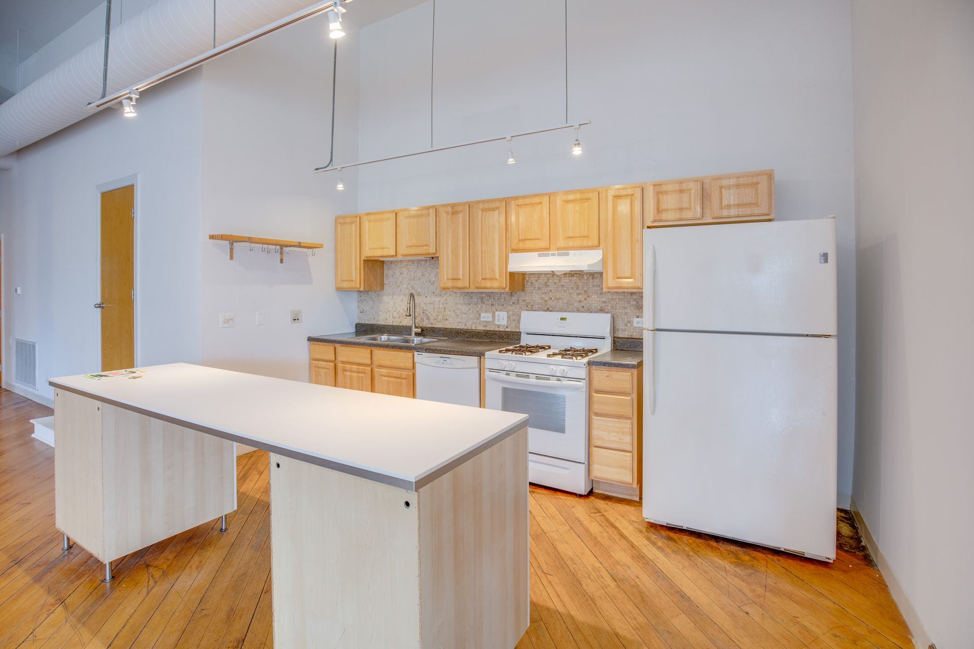 A kitchen with wooden cabinets and a white refrigerator