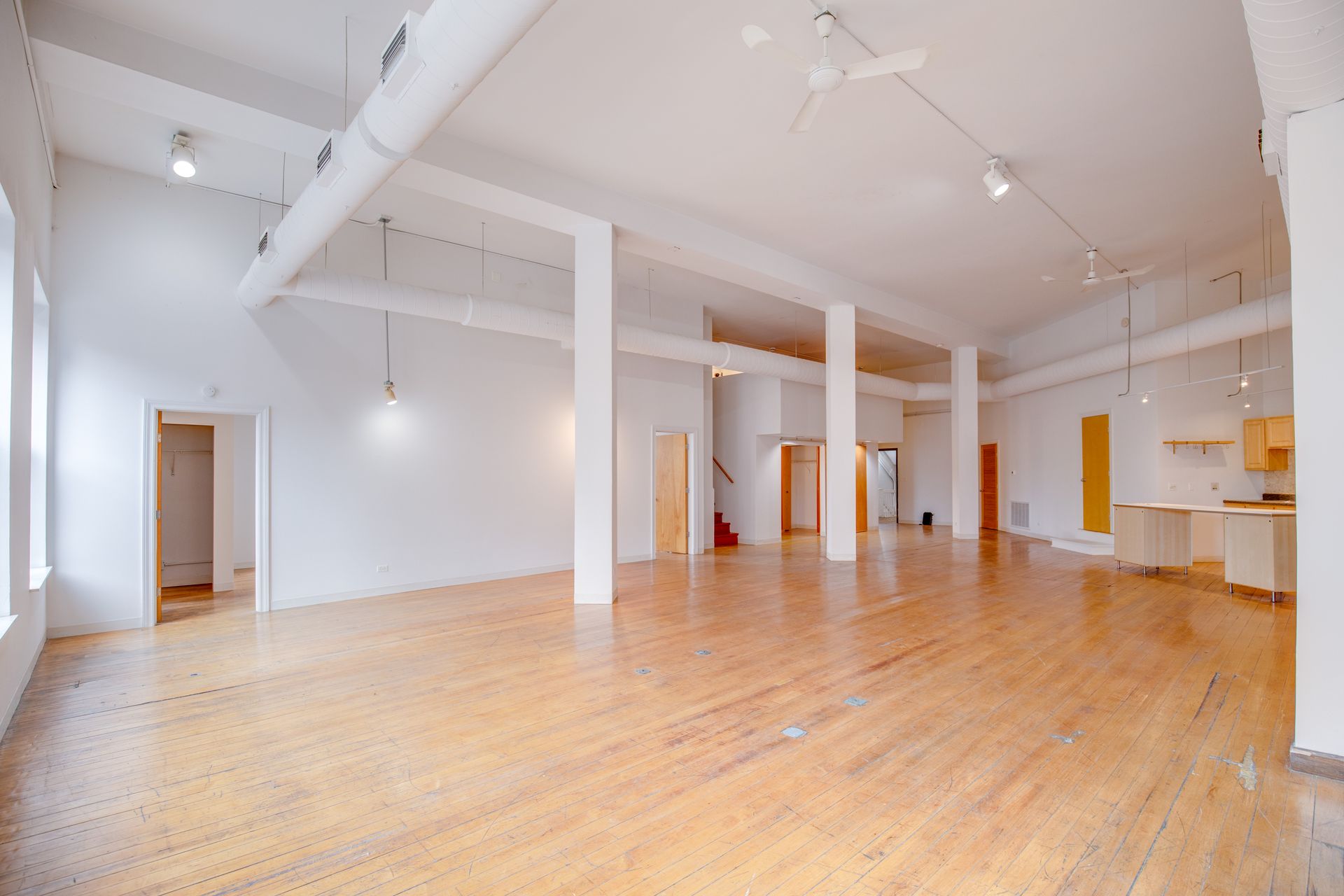 A large empty room with hardwood floors and white walls