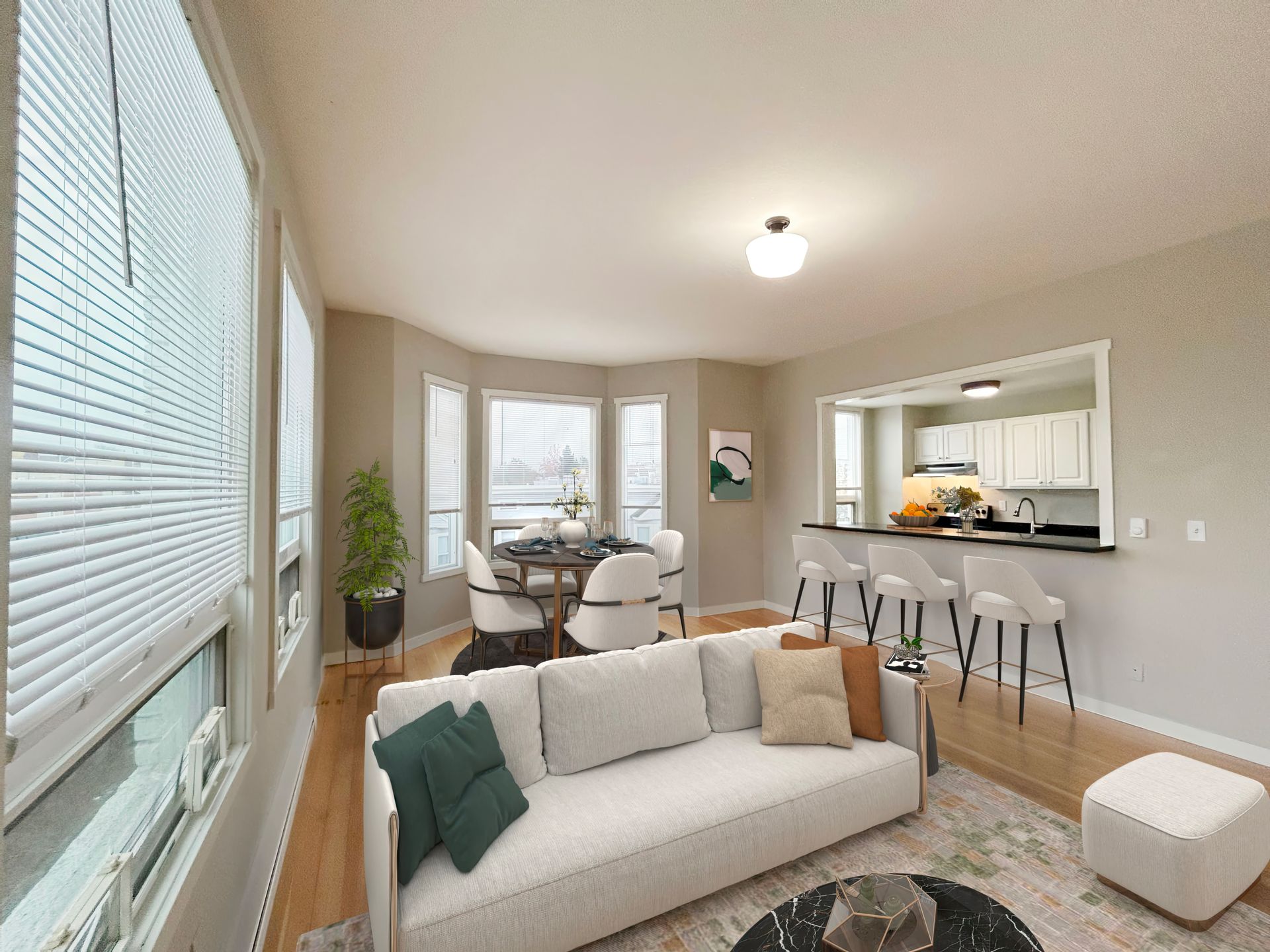 A living room with a white couch and a dining room in the background.