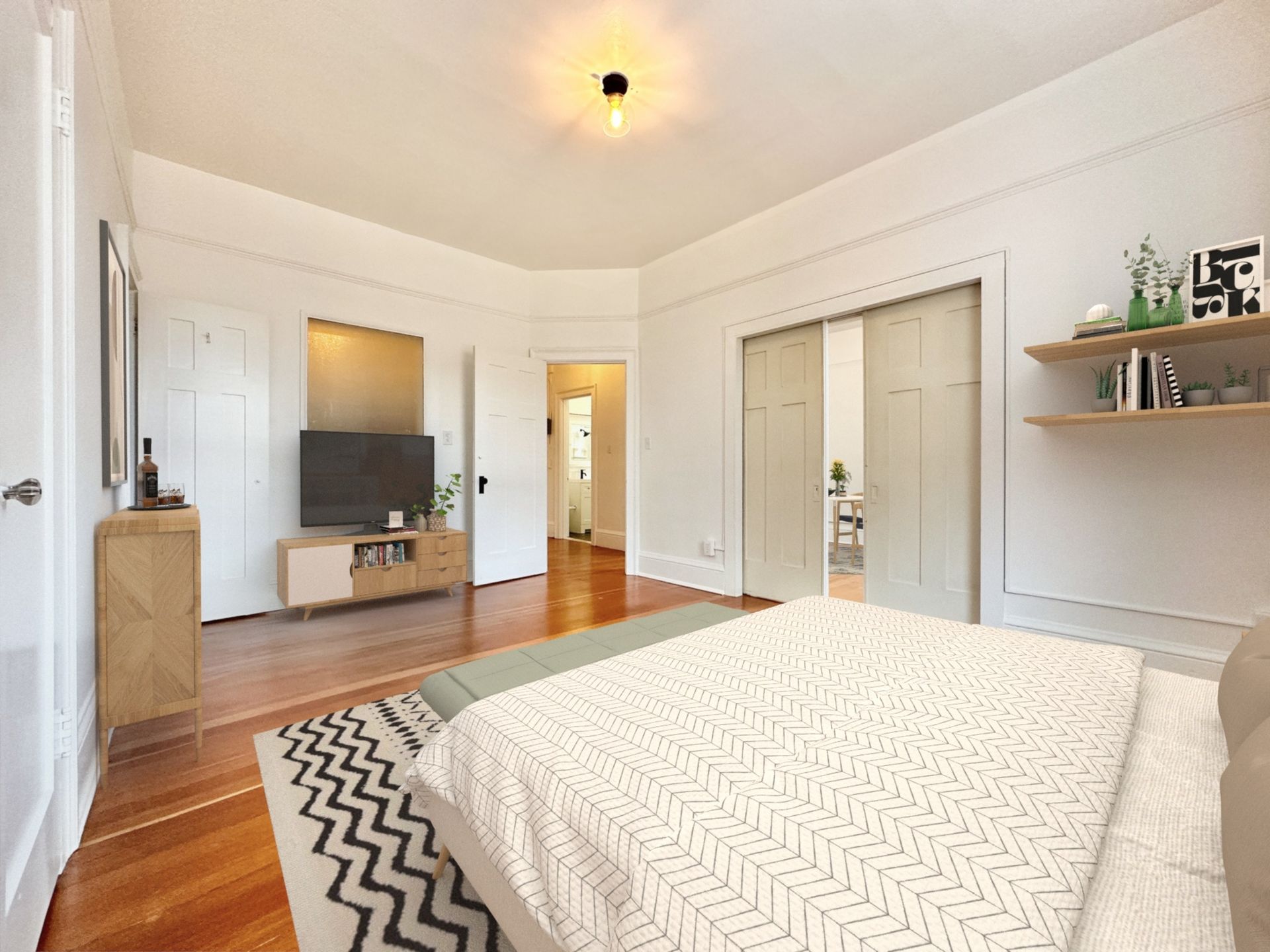 A bedroom with a large bed and a flat screen tv.