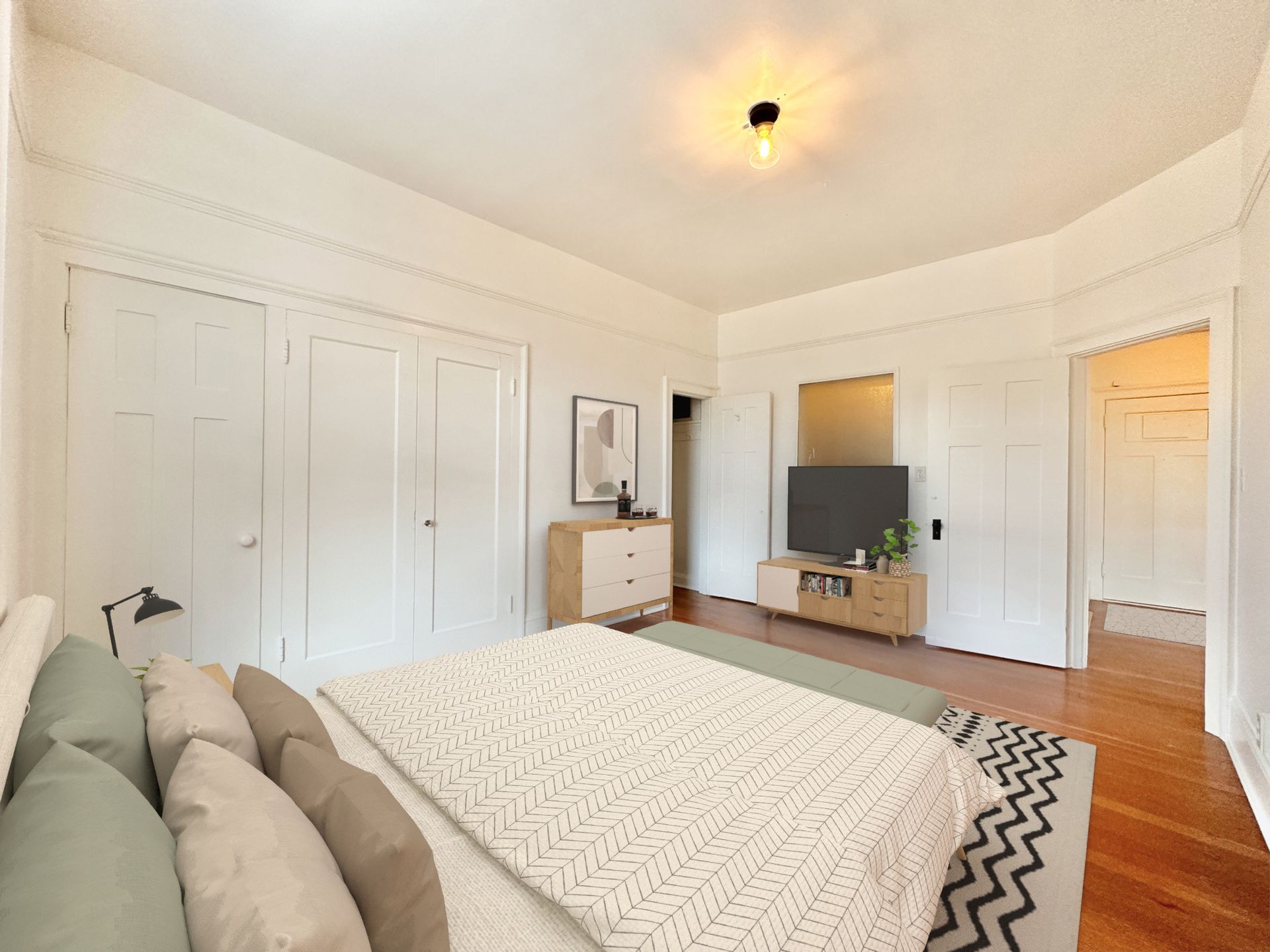 A bedroom with a large bed and a flat screen tv.