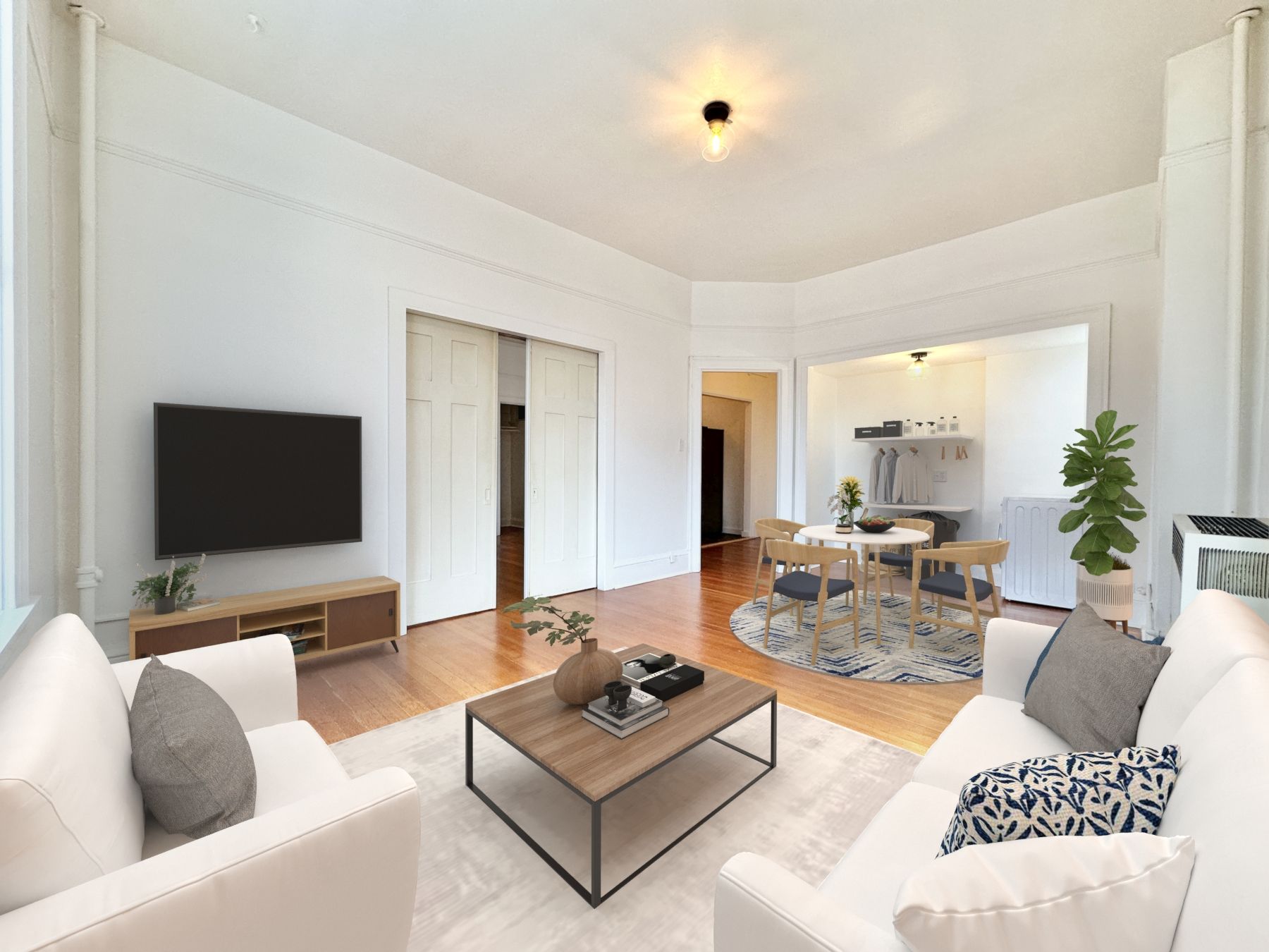 A living room with a couch , chair , coffee table and television.