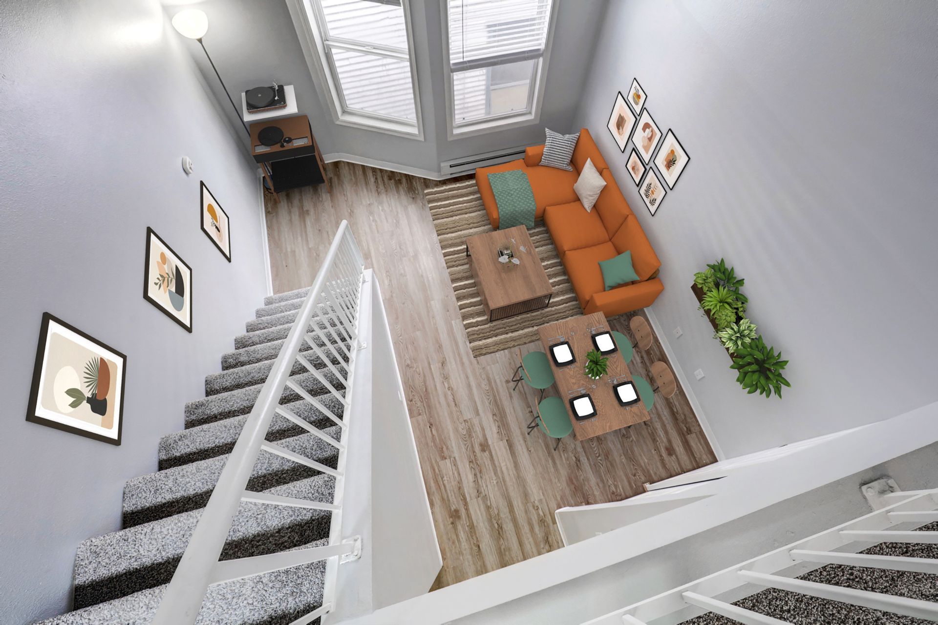 An aerial view of a living room with stairs leading up to it.