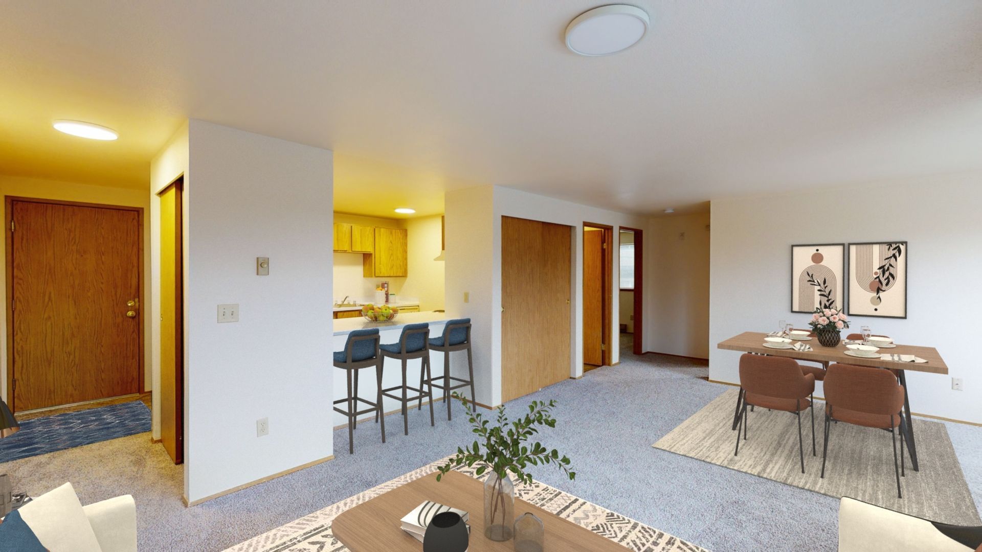 A living room with a dining table and chairs and a kitchen.