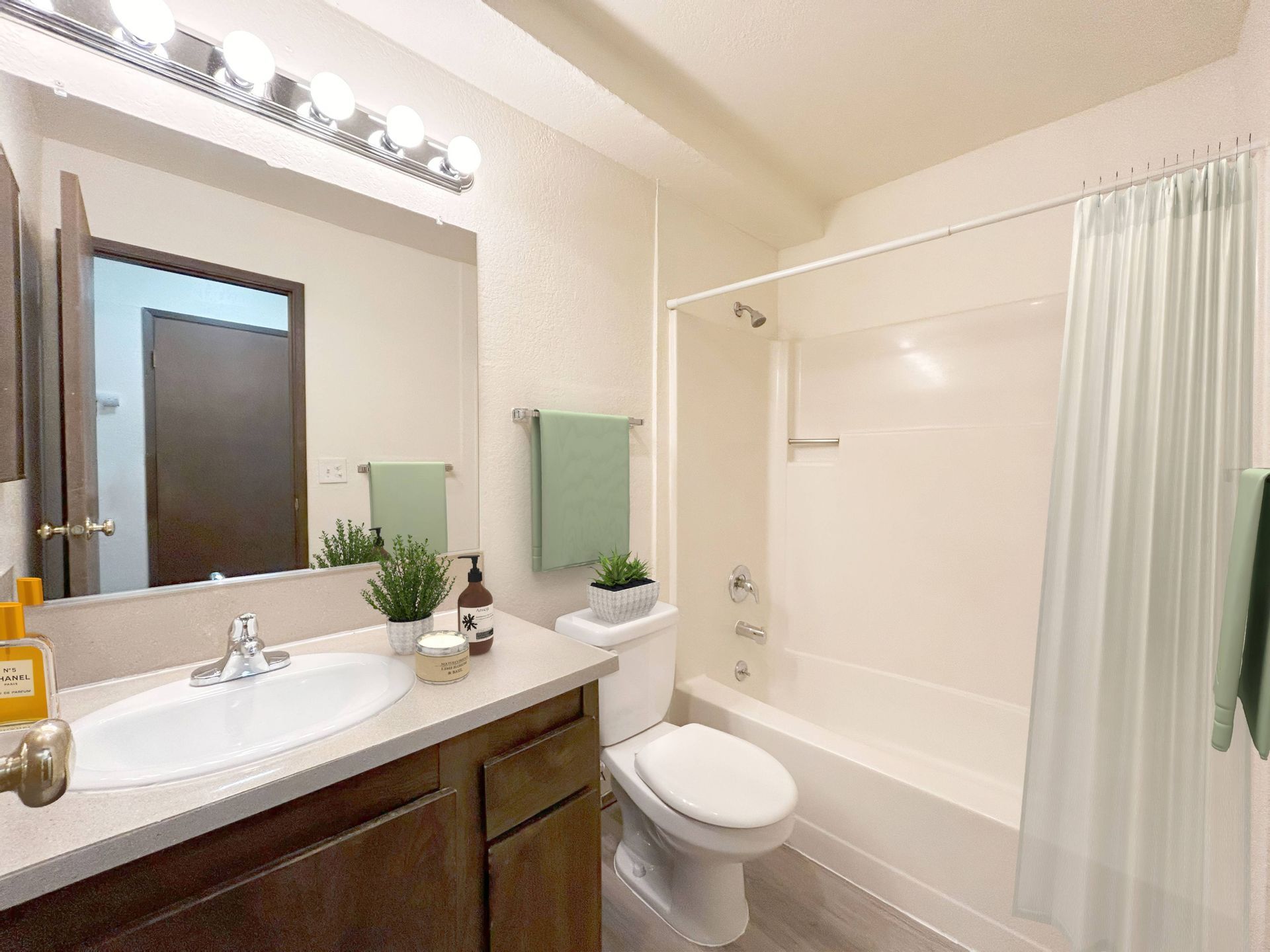A bathroom with a sink , toilet , tub and mirror.