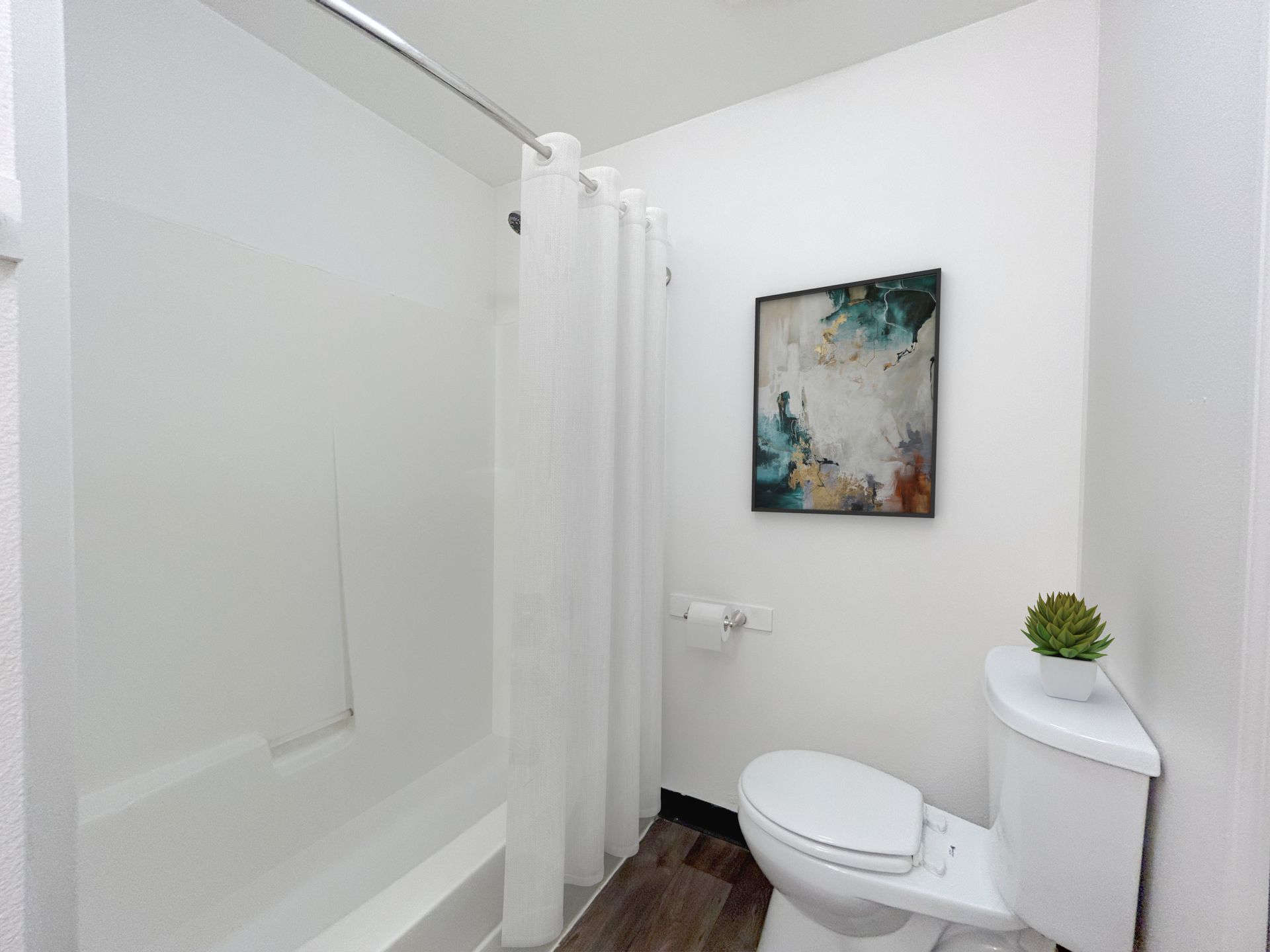A bathroom with a toilet , tub and shower.