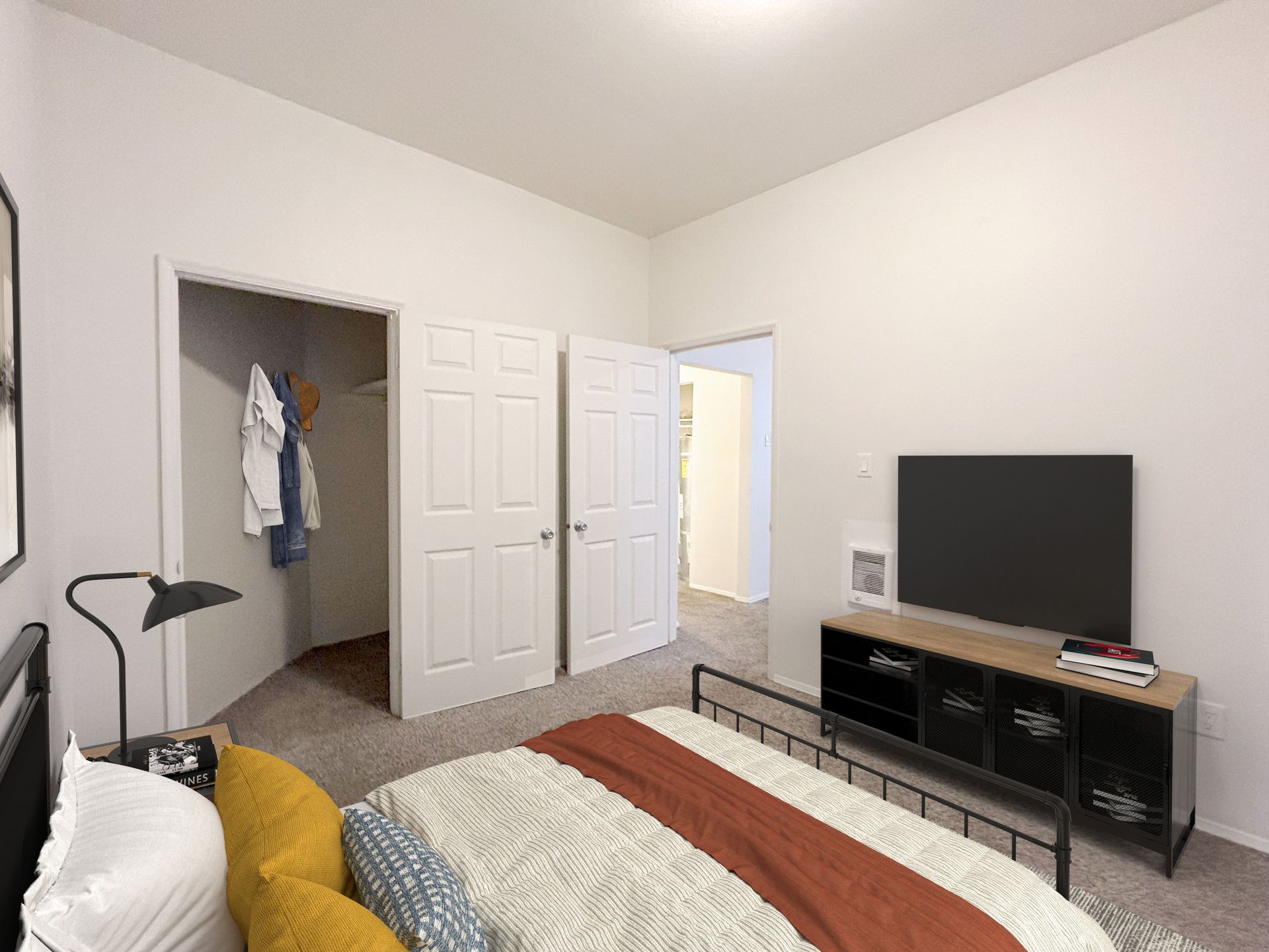 A bedroom with a bed , television and closet.