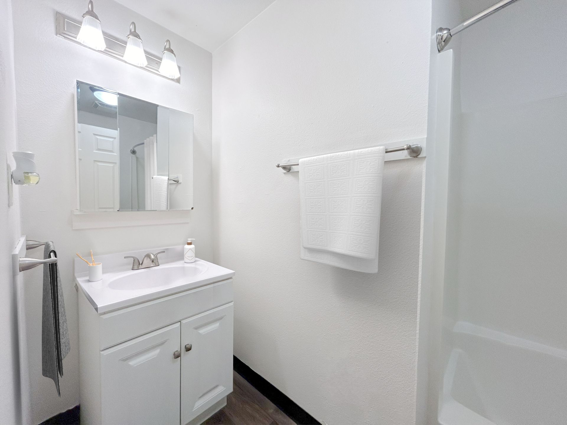 A bathroom with a sink , mirror , and shower.