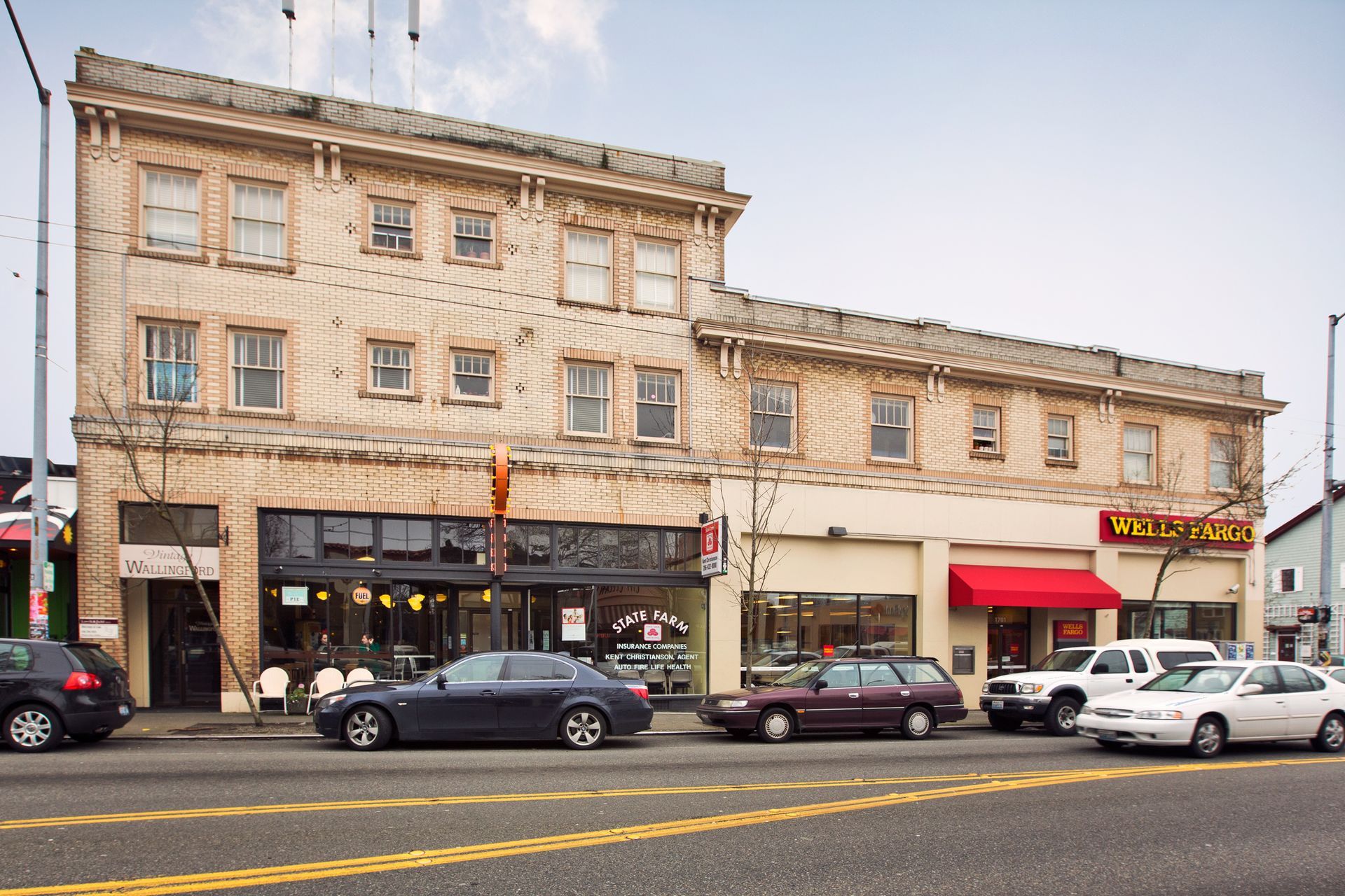 A row of cars are parked in front of a building that says mcdonald 's