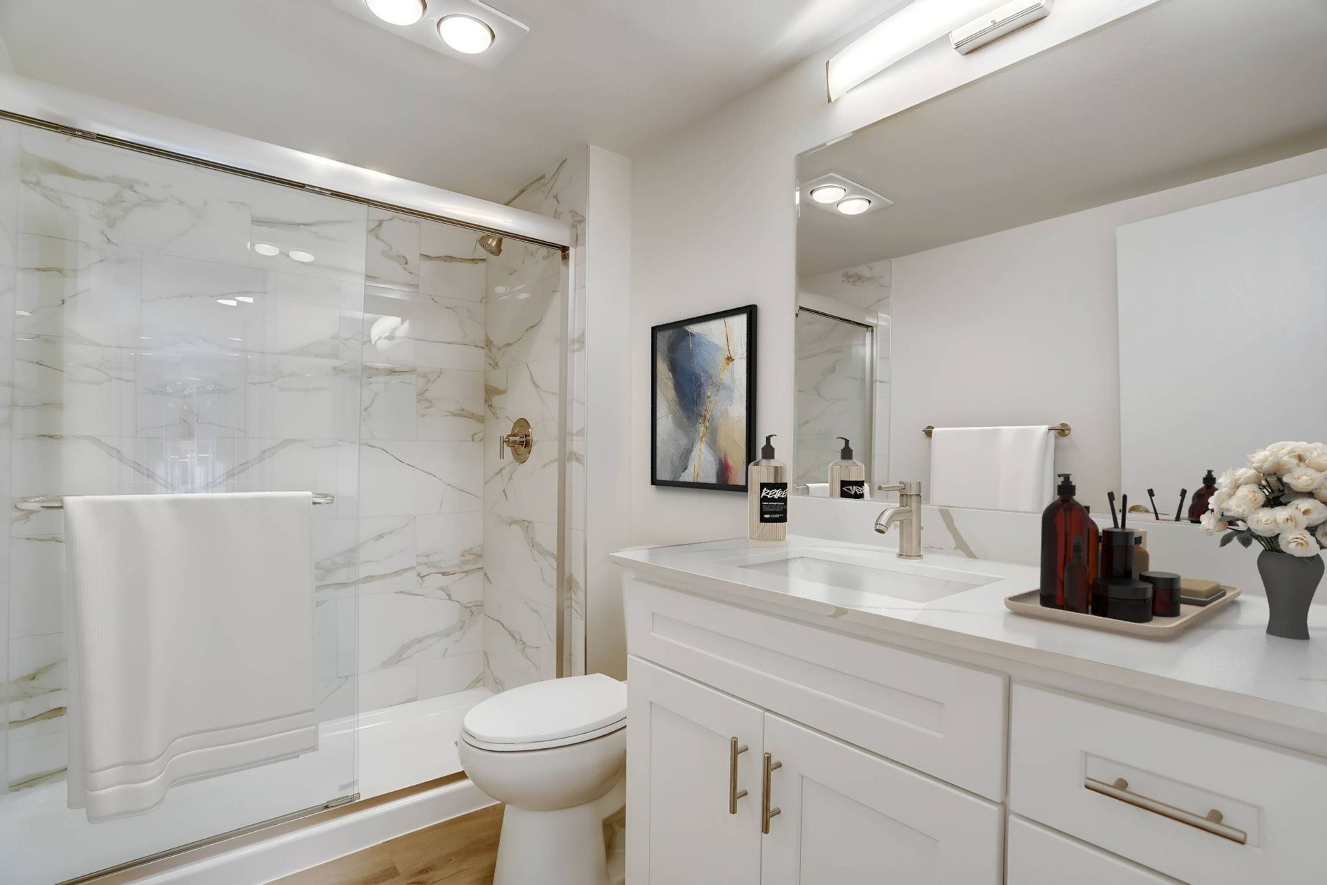 A bathroom with a toilet , sink , and shower.