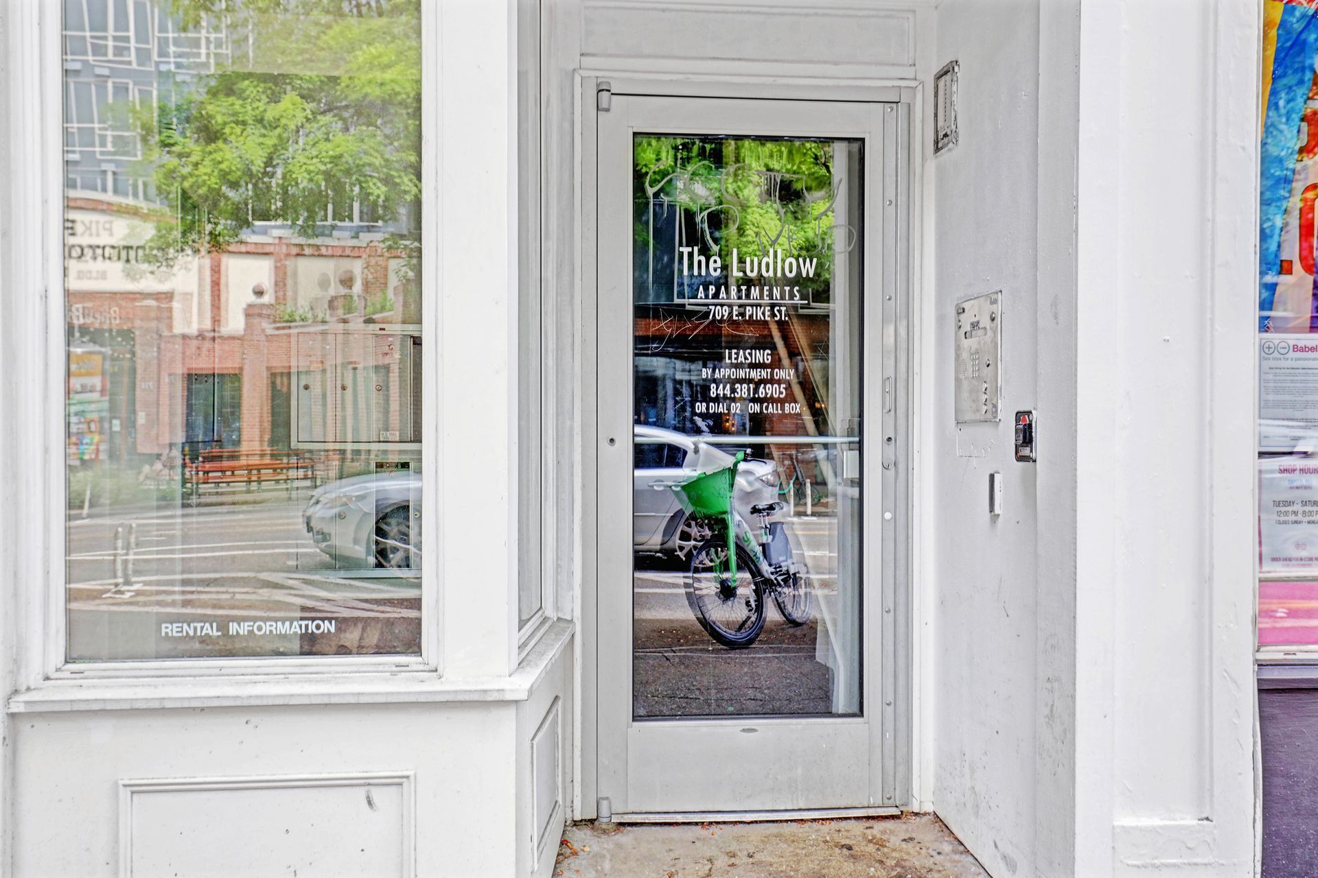A white building with a glass door and a motorcycle parked in front of it.