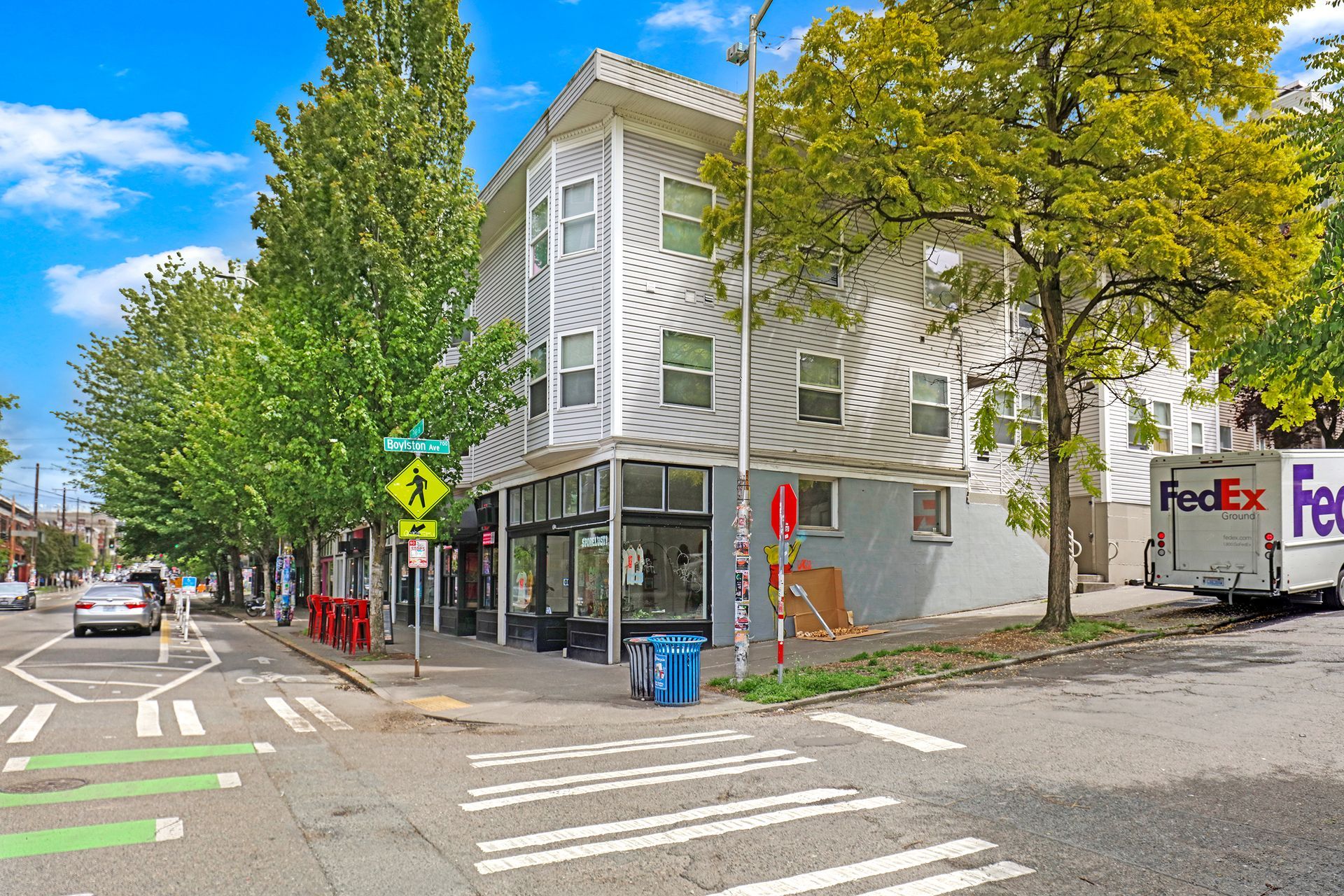 A fedex truck is parked on the side of the road in front of a building.