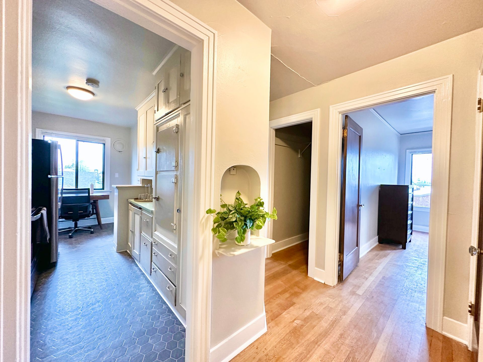 A hallway leading to a kitchen and a living room in a house.