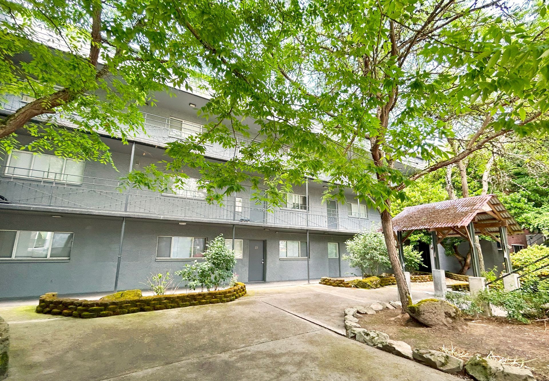 A large building with lots of windows and trees in front of it.