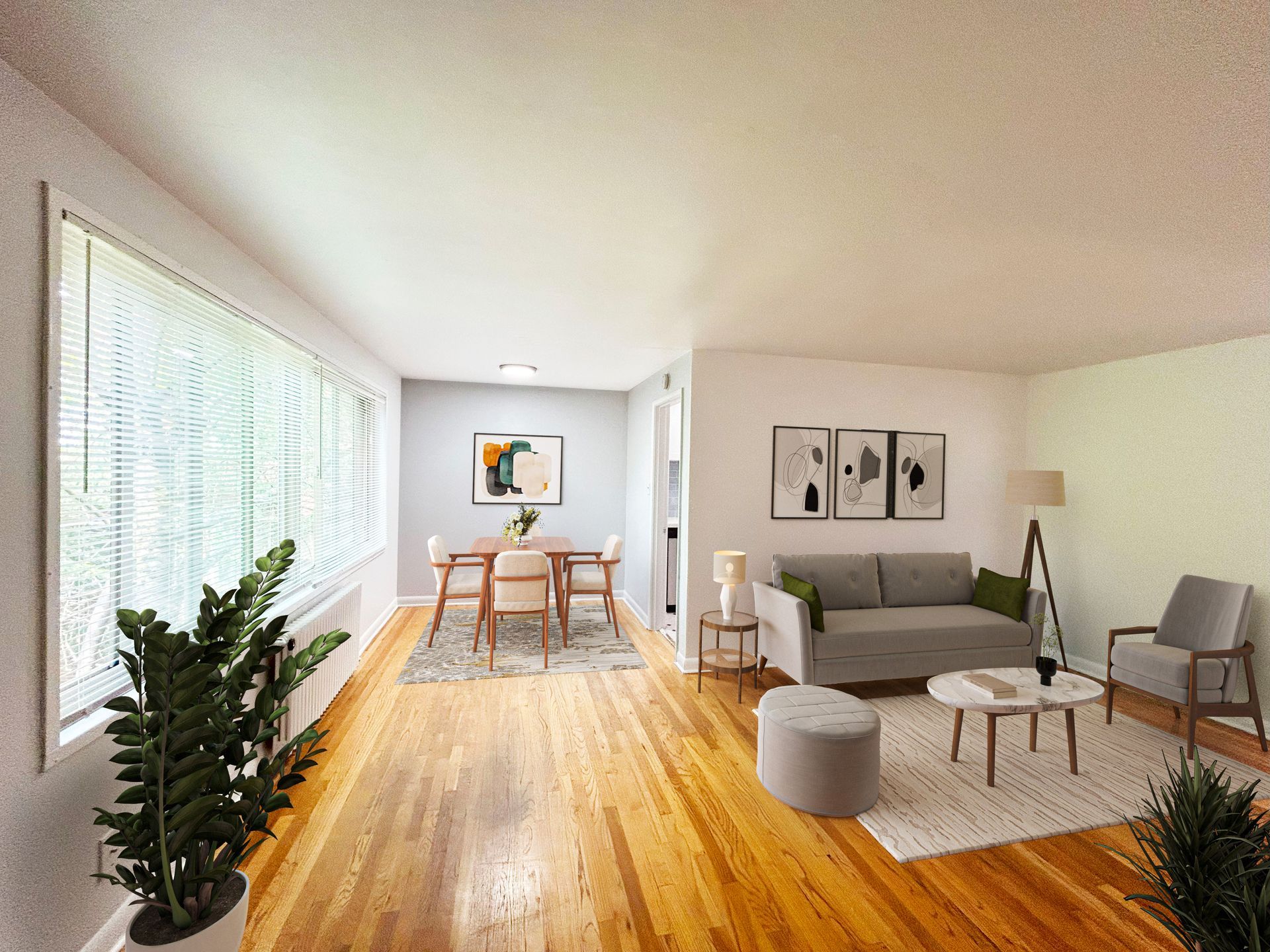 A living room with hardwood floors , a couch , chairs , and a table.