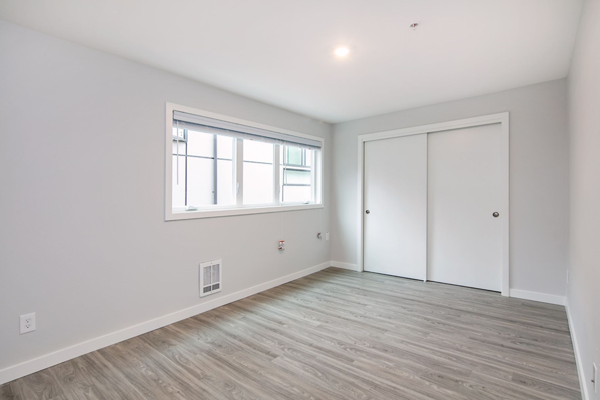 A living room with a dining table and chairs and a kitchen.