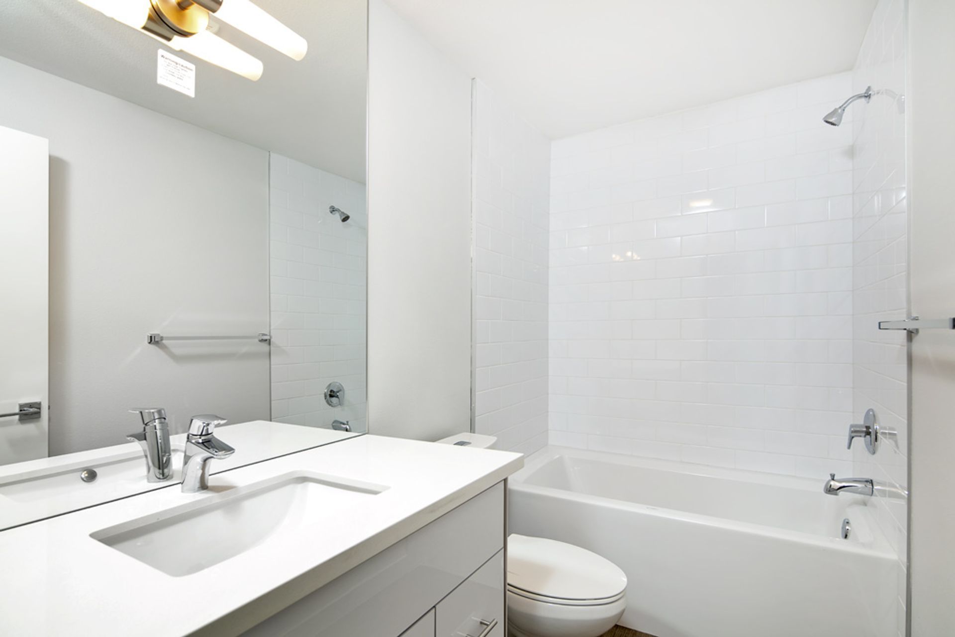 A bathroom with a tub , toilet , sink and mirror.