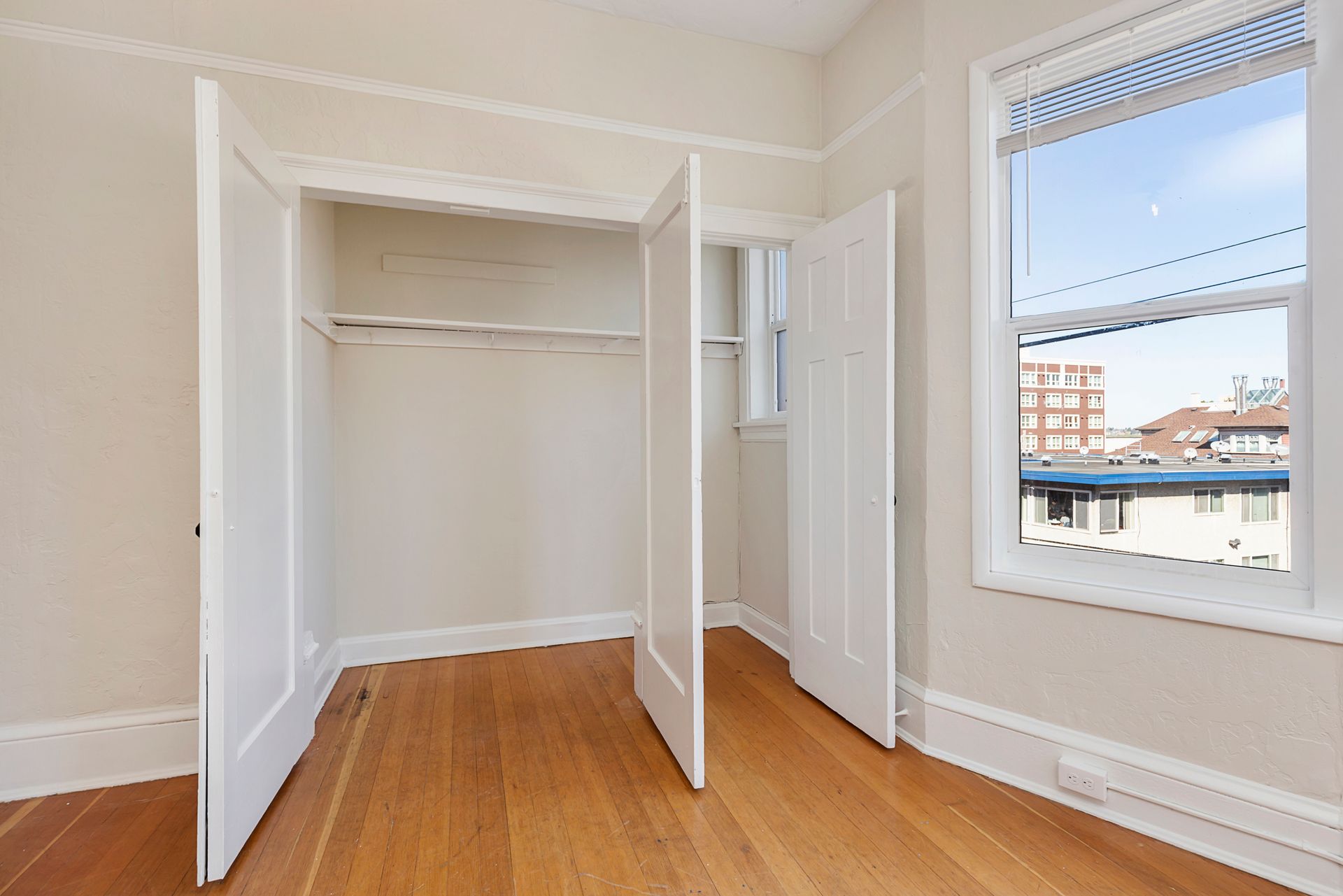 An empty room with hardwood floors and a window
