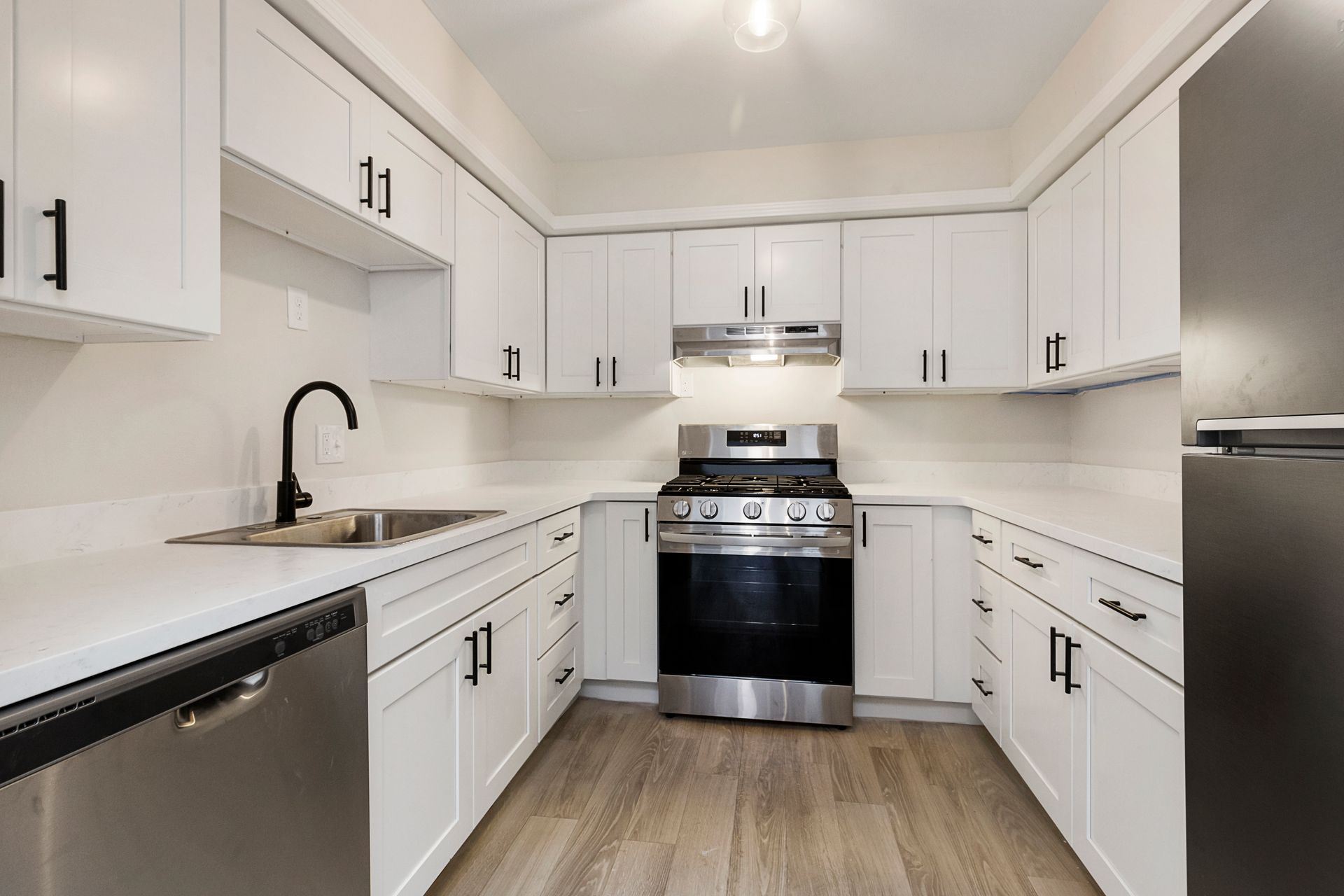 A kitchen with white cabinets and stainless steel appliances