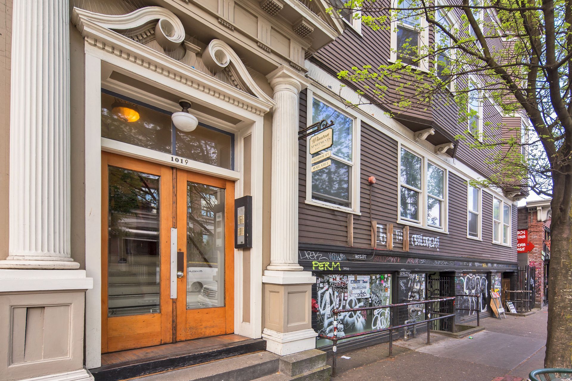 A building with a wooden door and columns on the side of it.