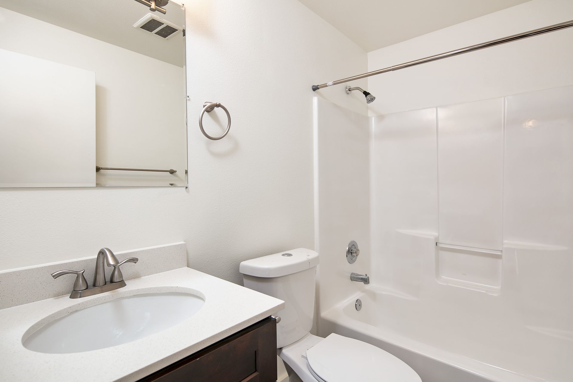 A bathroom with a sink , toilet , bathtub and mirror.