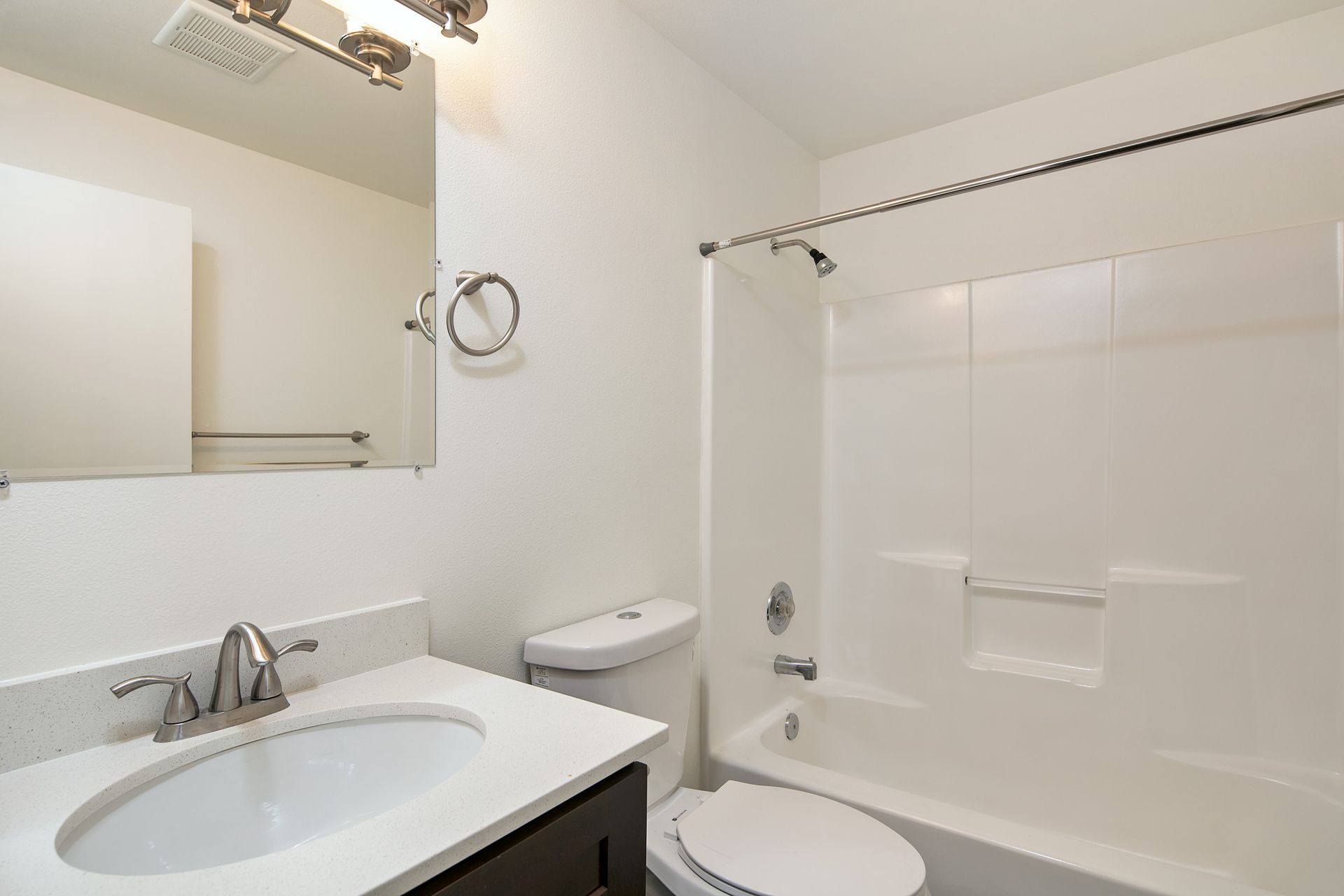 A bathroom with a sink , toilet , bathtub and mirror.