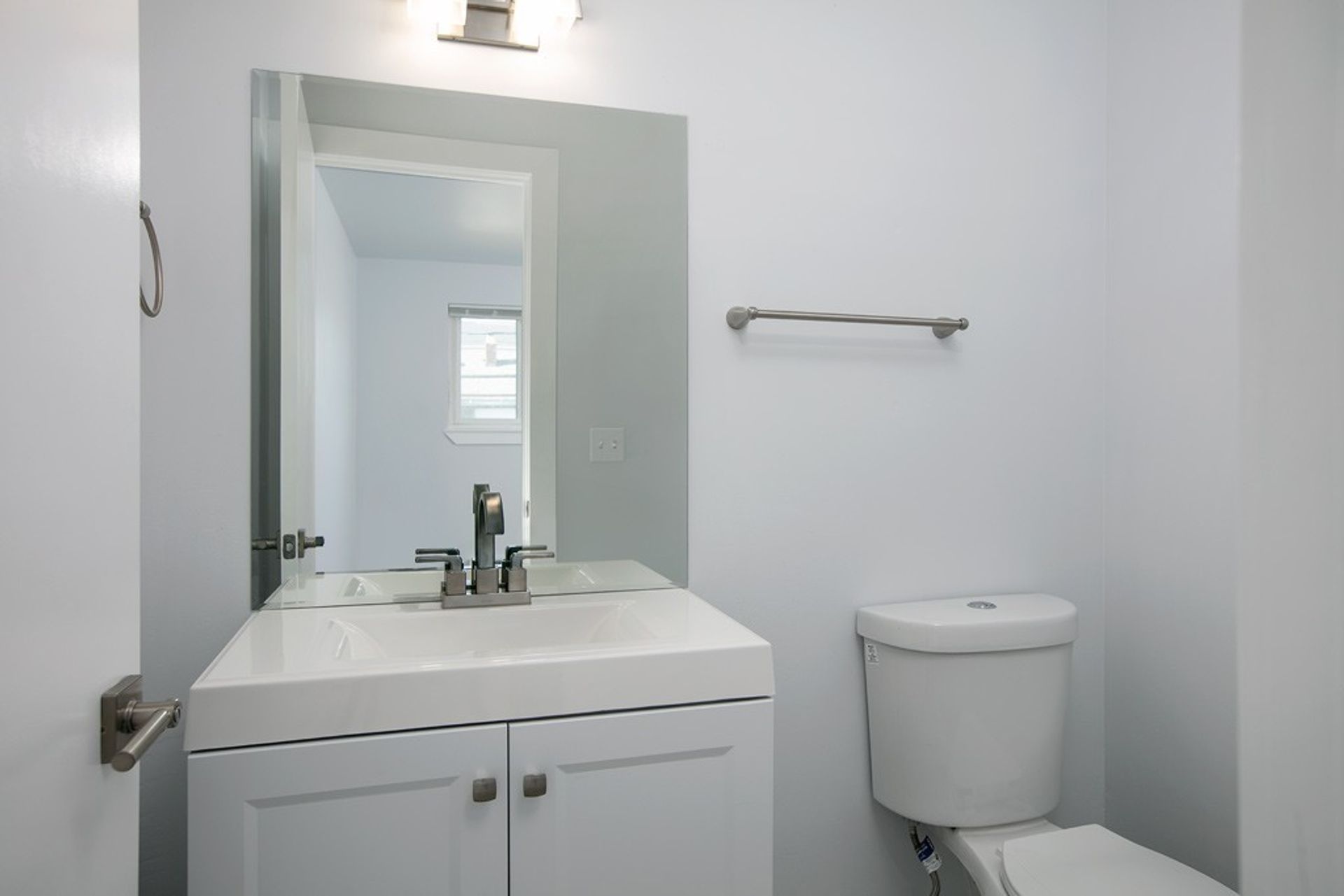 A bathroom with a sink , toilet and mirror.