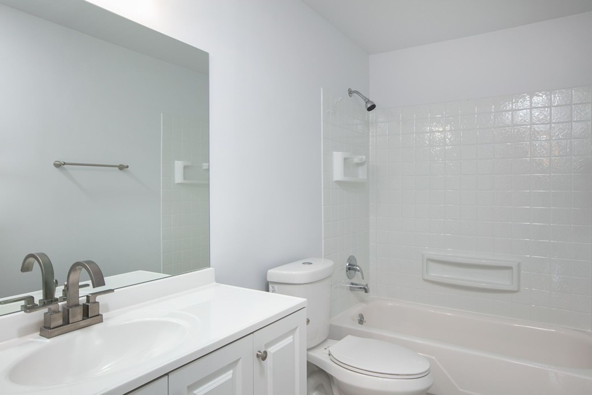 A bathroom with a sink , toilet , bathtub and mirror.