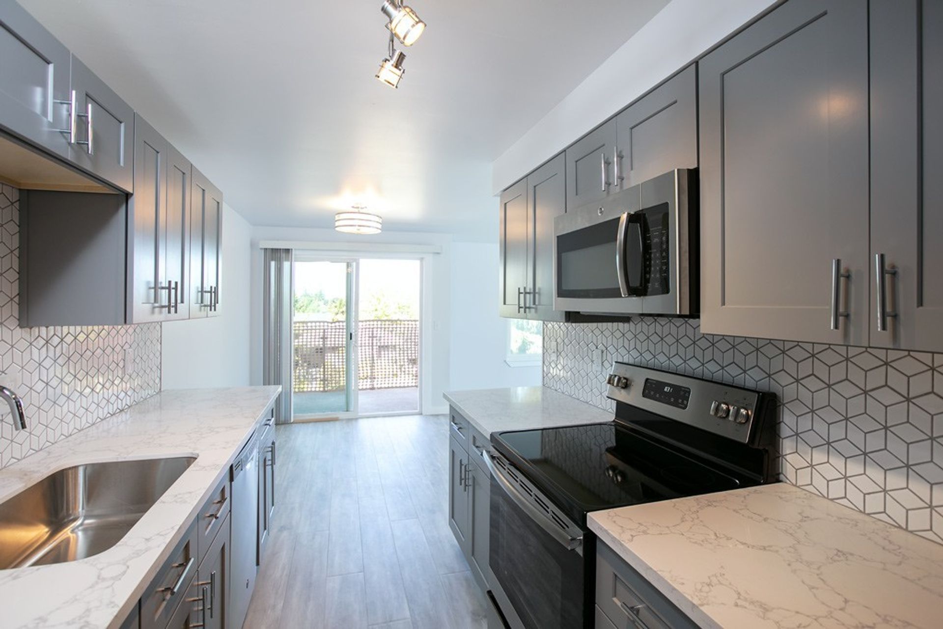 A kitchen with stainless steel appliances and gray cabinets