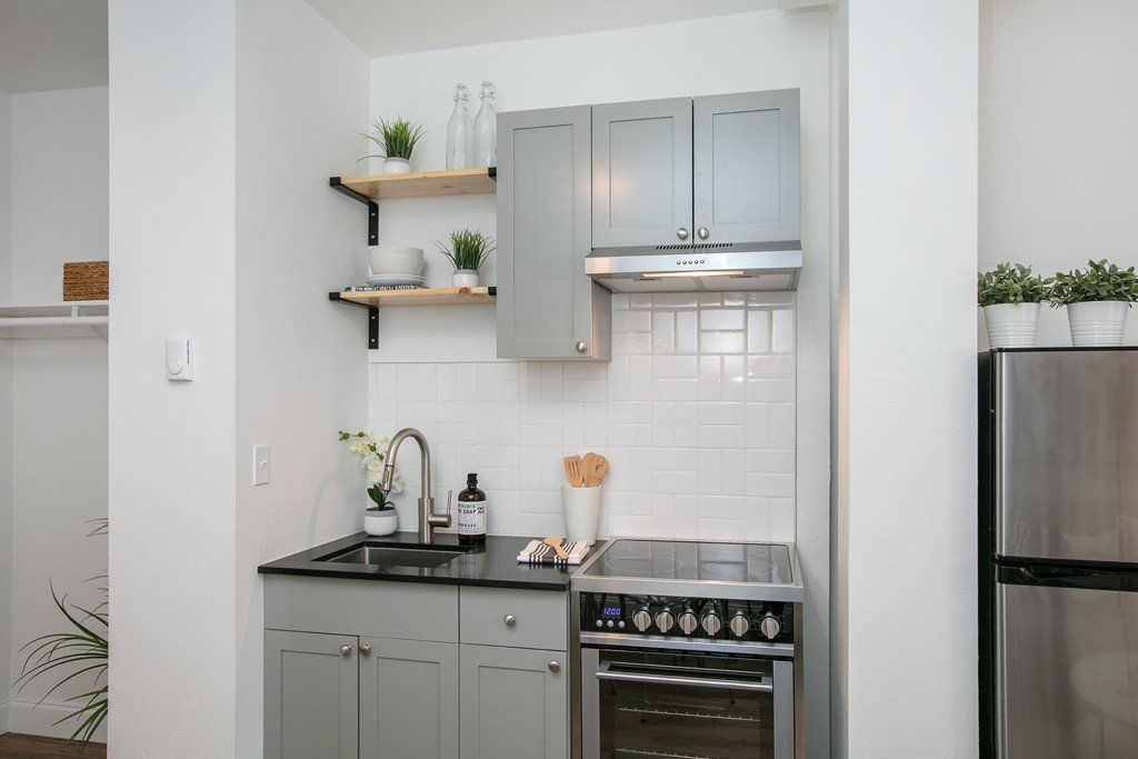 A kitchen with a stove , oven , sink , and refrigerator.