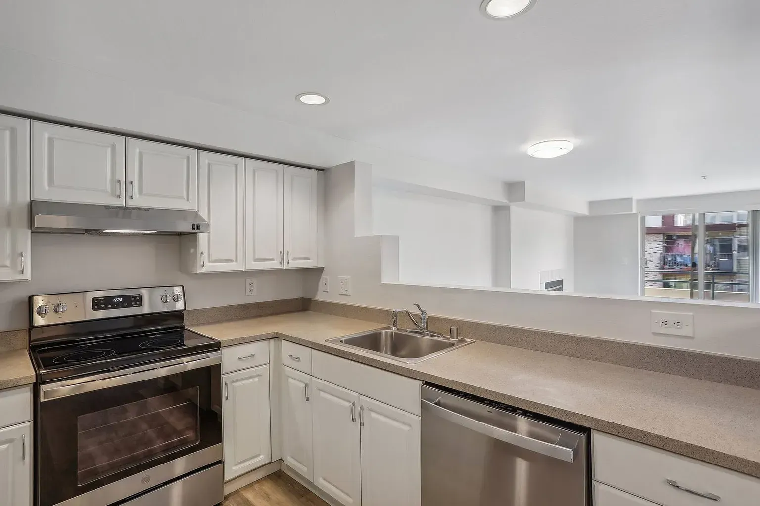 A kitchen with white cabinets and stainless steel appliances