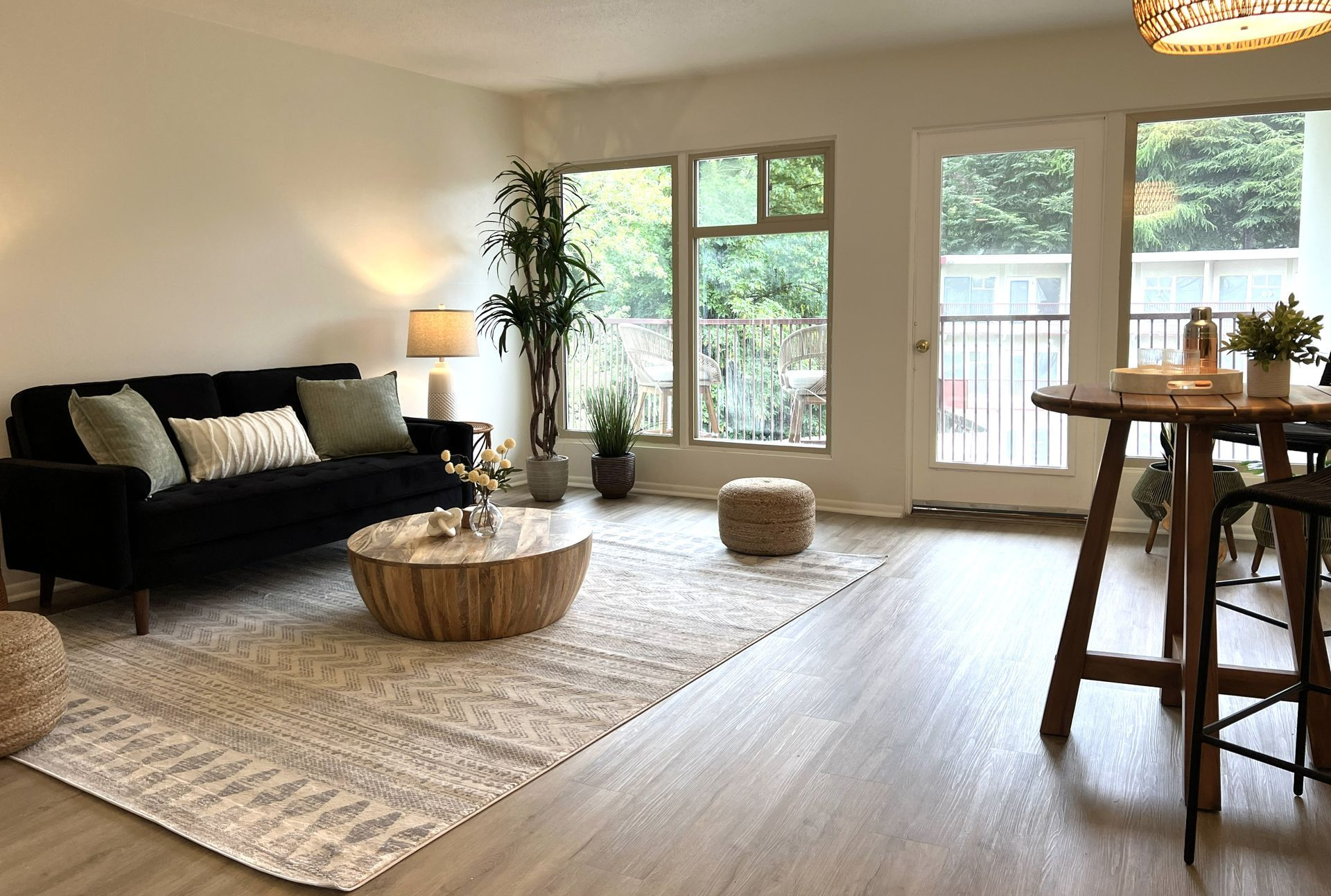 A bedroom with a bed , stool , table and window.