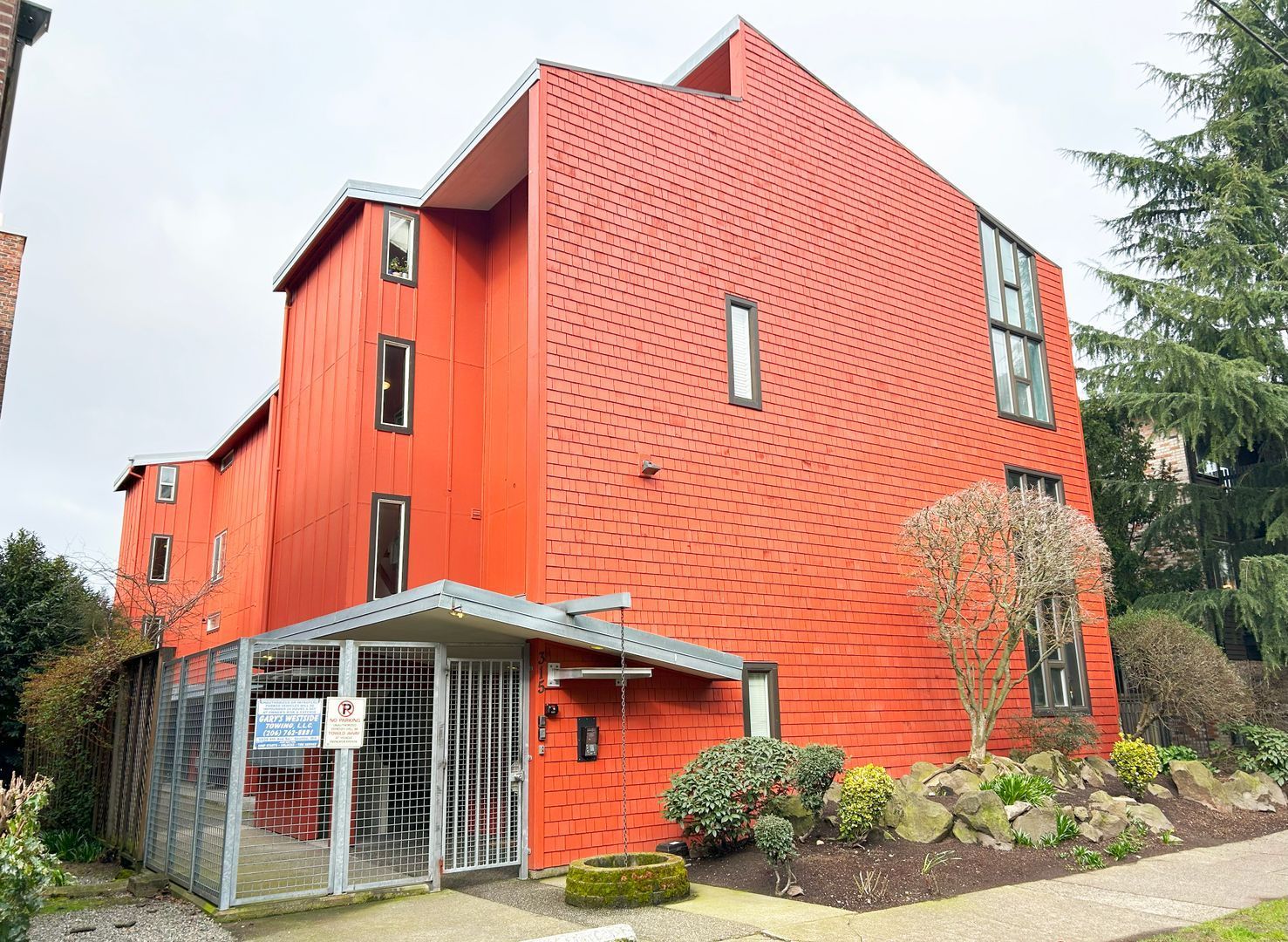 A large red building with a sign that says ' for sale ' on it