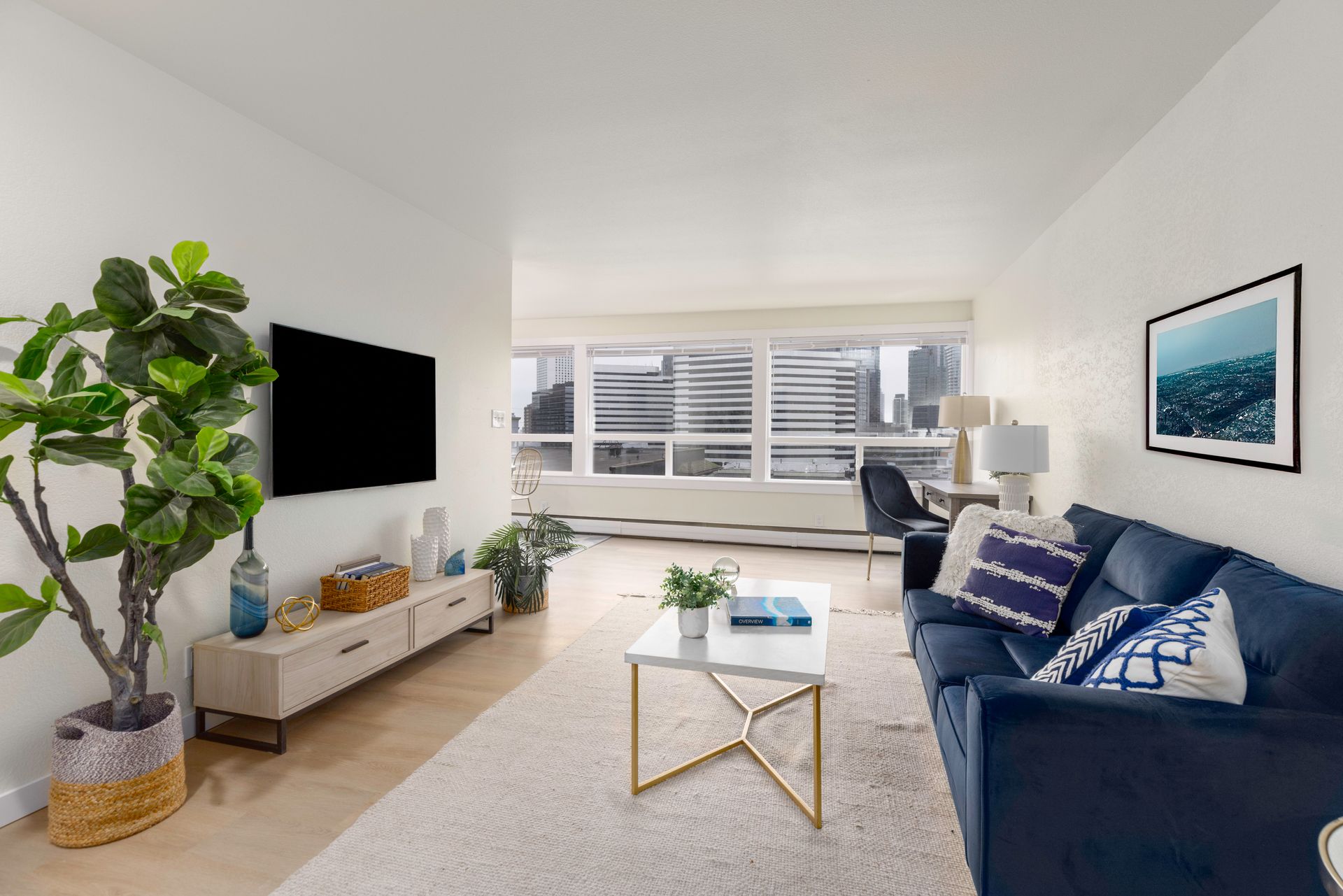 A living room with a couch , chair , table and television.