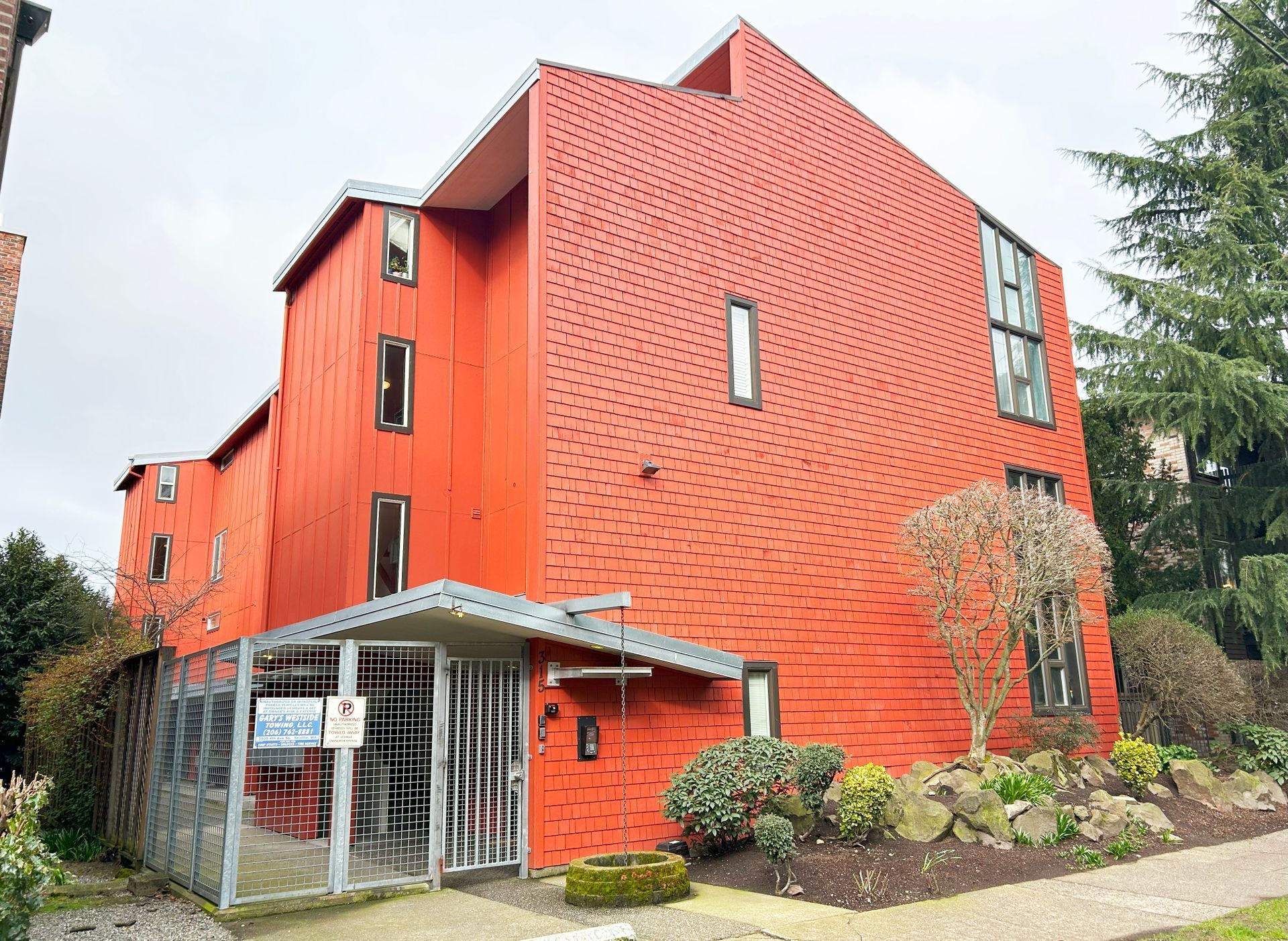 A red building with a sign that says ' for sale ' on it