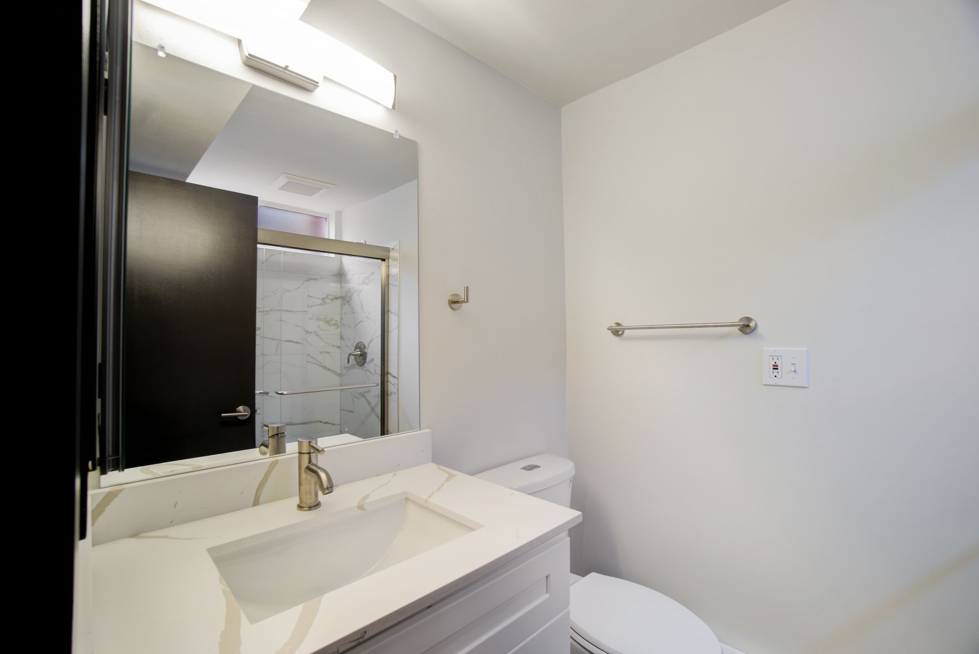 A bathroom with a sink , toilet and mirror.